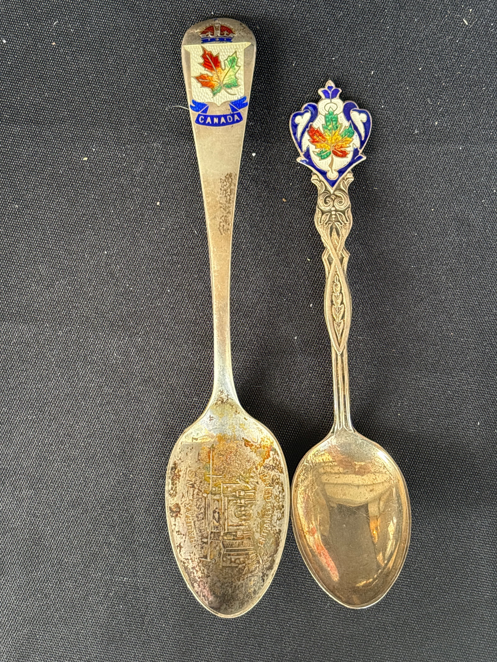 Two sterling Canadian souvenir spoon enameled maple leaf &crown design; 44 grams: Two Canadian souvenir spoon featuring a maple leaf and crown design on the handle and an engraved scene in the bowl. Material: Often constructed from sterling silver. Design: Enamel-accented handle wi