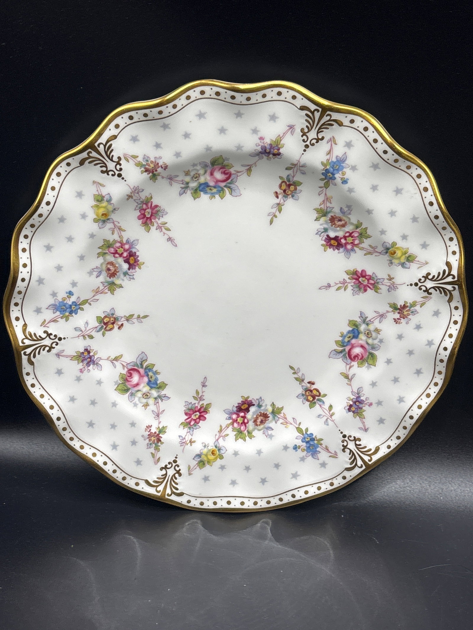 Wavy edge Royal Crown Derby Royal Antoinette collection 8 inch plate: Royal Crown Derby Royal Antoinette collection.The design, originally created in the late 1800s and updated in 1959, is crafted from fine bone china and features a 22K gold scalloped rim with a delicat
