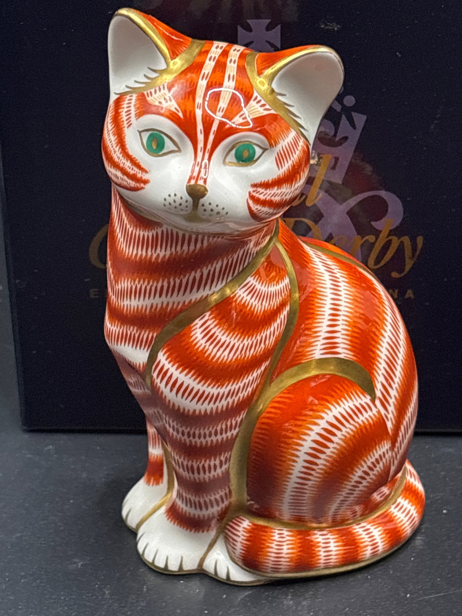 Emerald eyes Royal Crown Derby Ginger Cat 5.25 inch paperweight: Gold stopper, with box. This figurine is a Royal Crown Derby Ginger Cat Paperweight, a highly collectible piece of fine English bone china. It is characterized by its distinctive orange and white "Ima