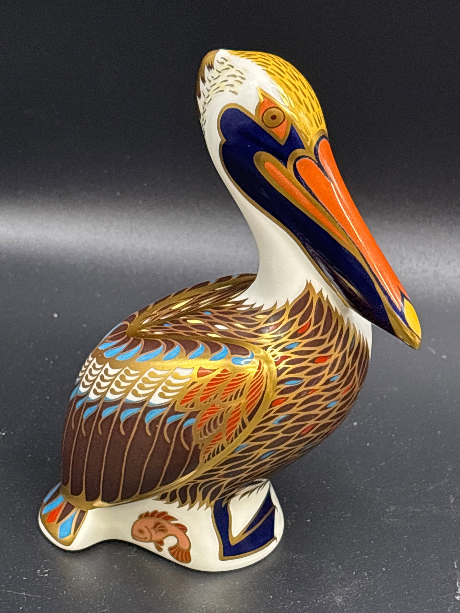 Brown Pelican Royal Crown Derby china 5.25 inches paperweight: Gold stopper, no box. Royal Crown Derby Imari collection brown pelican paperweight.Design Details: The piece features 22ct gold gilding and a silver stopper on the underside.Production: It was introdu