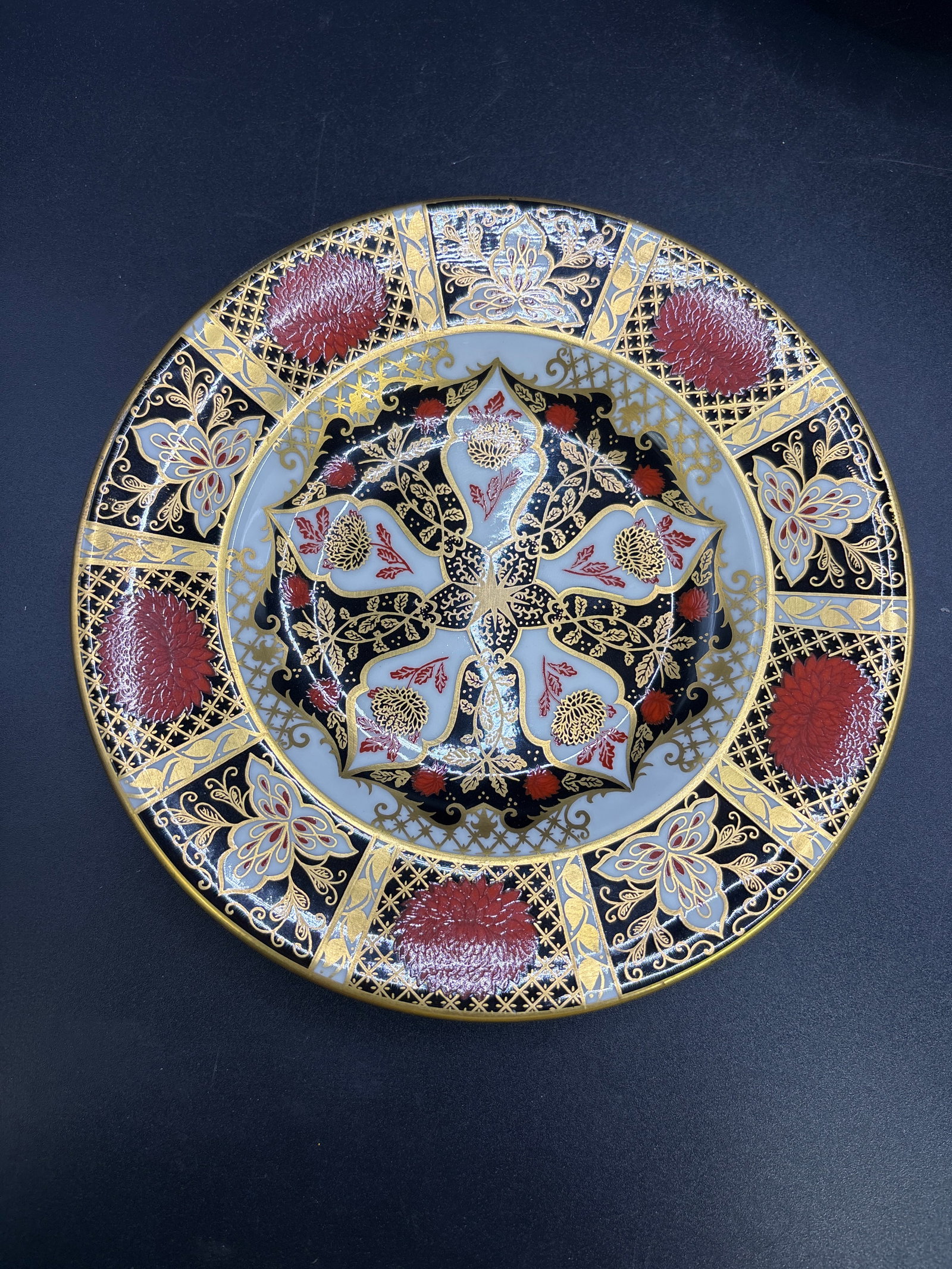 Abbeydale Chrysanthemum pattern bone china small 6&3/8 inch plate: Chrysanthemum pattern bone china plate made by Abbeydale in Duffield, Derbyshire, England.This Imari-style design features a striking contrast of cinnabar red, black, and white sections, all heavily a
