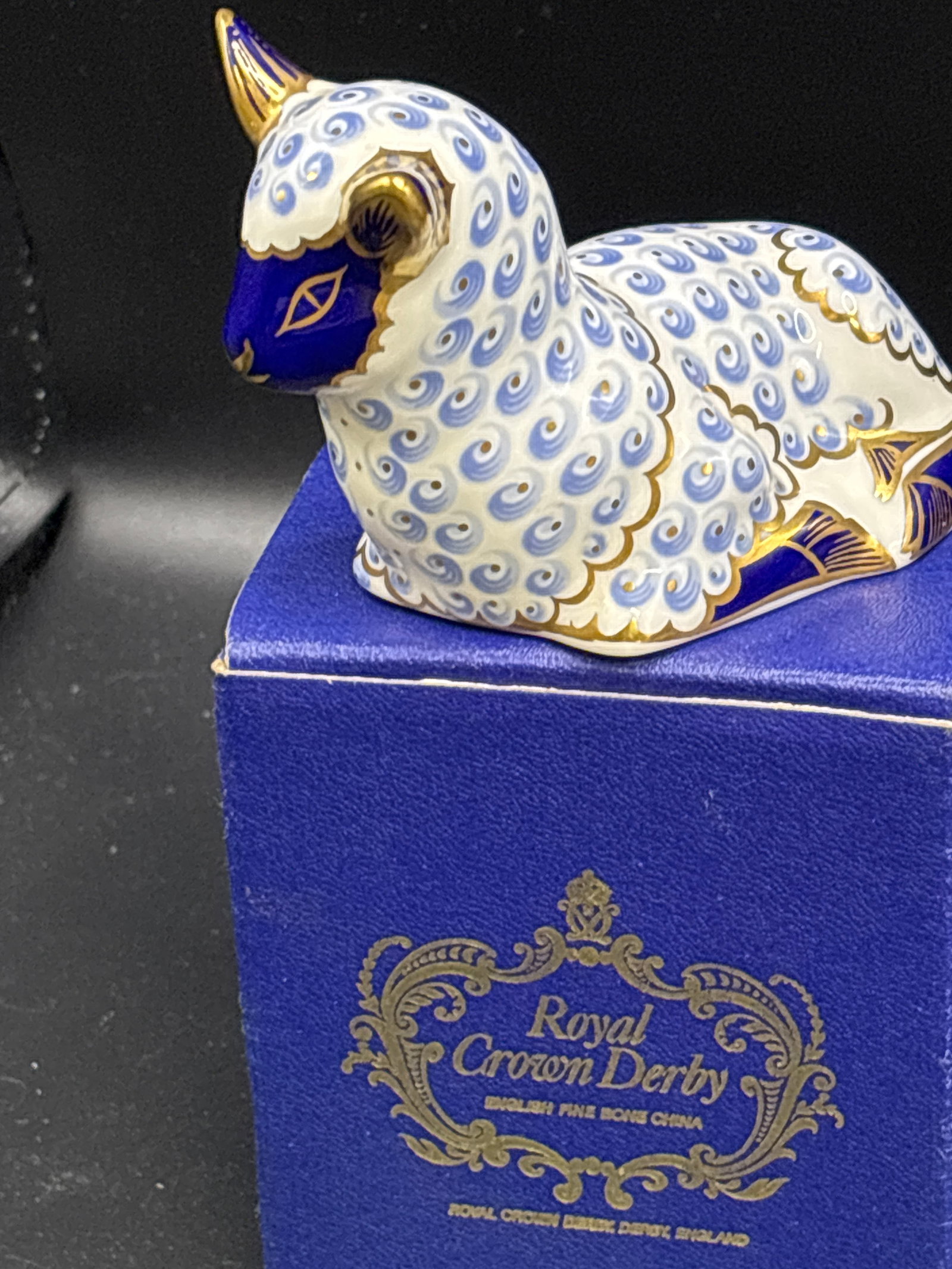 Resting lamb Royal Crown Derby bone china 3&1/2 inch paperweight: First Quality. Gold stopper. With box. Royal Crown Derby Lamb paperweight. Made from fine bone china in England, it features a distinctive pattern inspired by traditional Imari designs, often accented