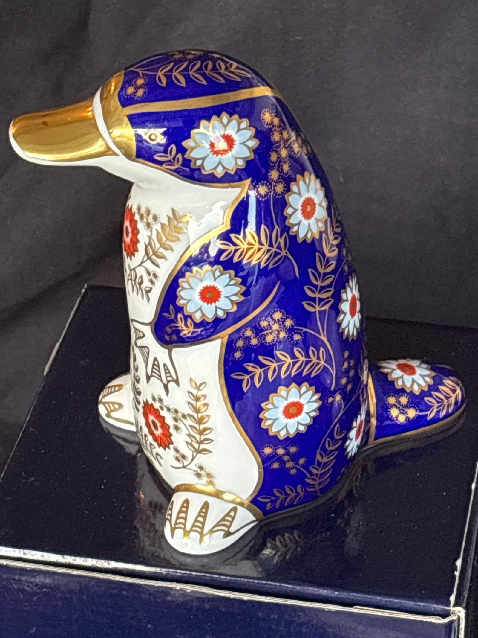Royal Crown Derby Imari patterned platypus 4&3/4 inch paperweight: Silver stopper. With box. Royal Crown Derby Imari patterned platypus paperweight featuring intricate blue, white, and red floral designs with gilt detailing. These collectible figurines were designed 