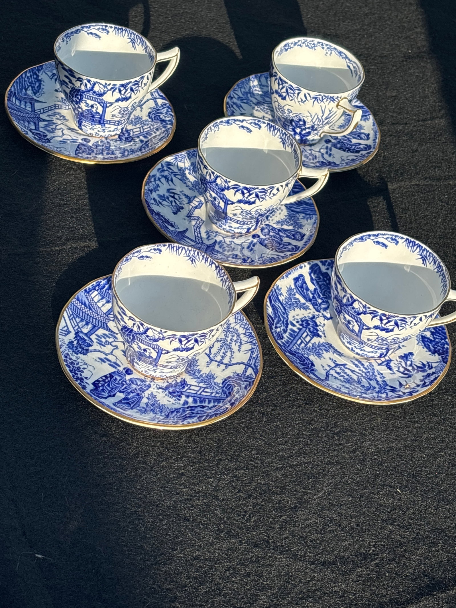 Five Royal Crown Derby demitasse cups and saucersin the popular "Mikado" pattern: Royal Crown Derby teacup and saucer in the popular "Mikado" pattern. This classic design features a blue transferware scene of pagodas, bamboo, and bridges, inspired by traditional Japanese art. 2&3/4