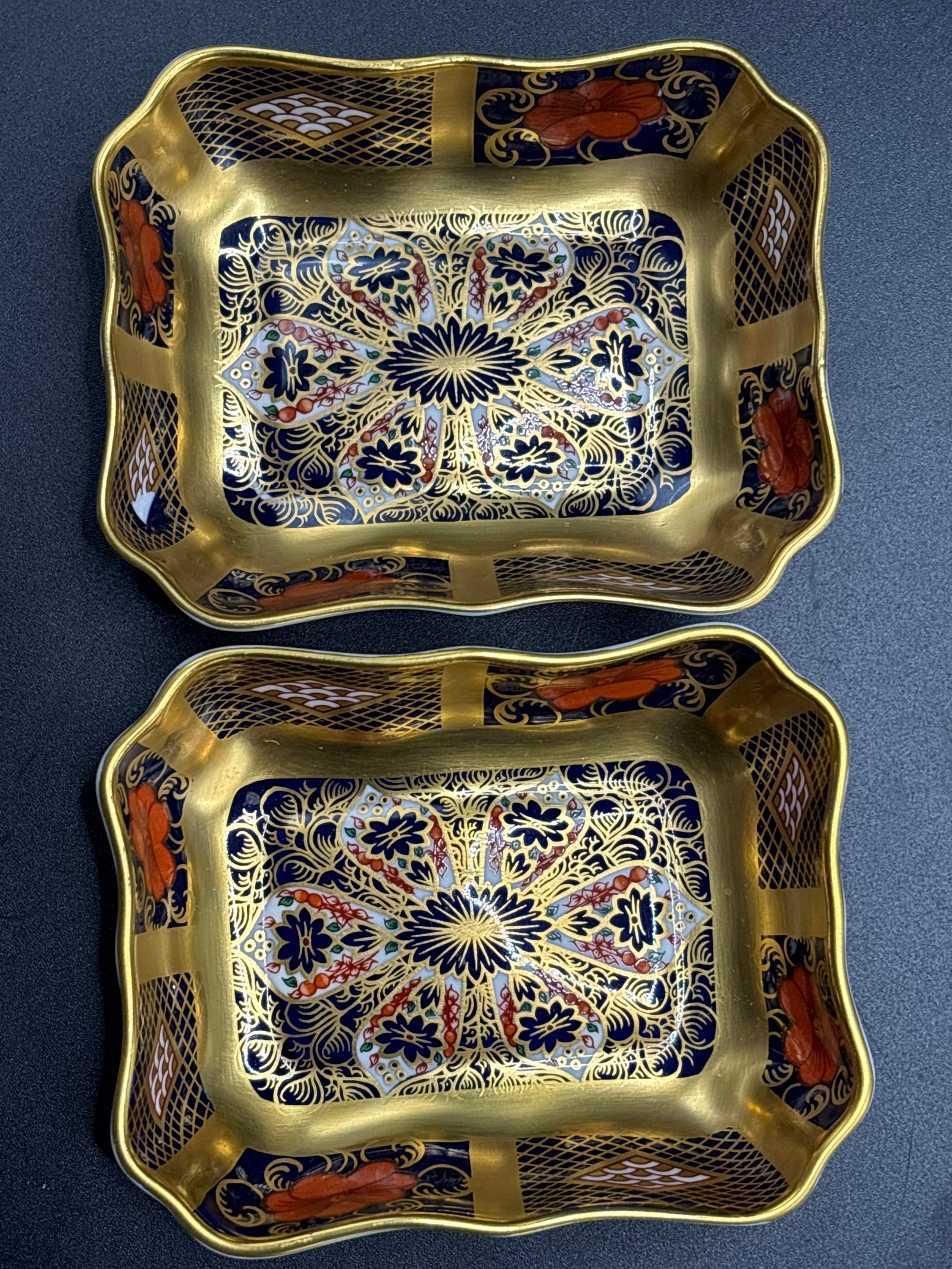 Gold band rectangular Pair Imari #1128 Royal Crown Derby porcelain 3&3/4 inch trinket dish: Pair rectangular Royal Crown Derby trinket dishes in the highly collectible Old Imari 1128 pattern. Pattern DetailsDesign: Features intricate floral and geometric motifs in cobalt blue, iron red, and 