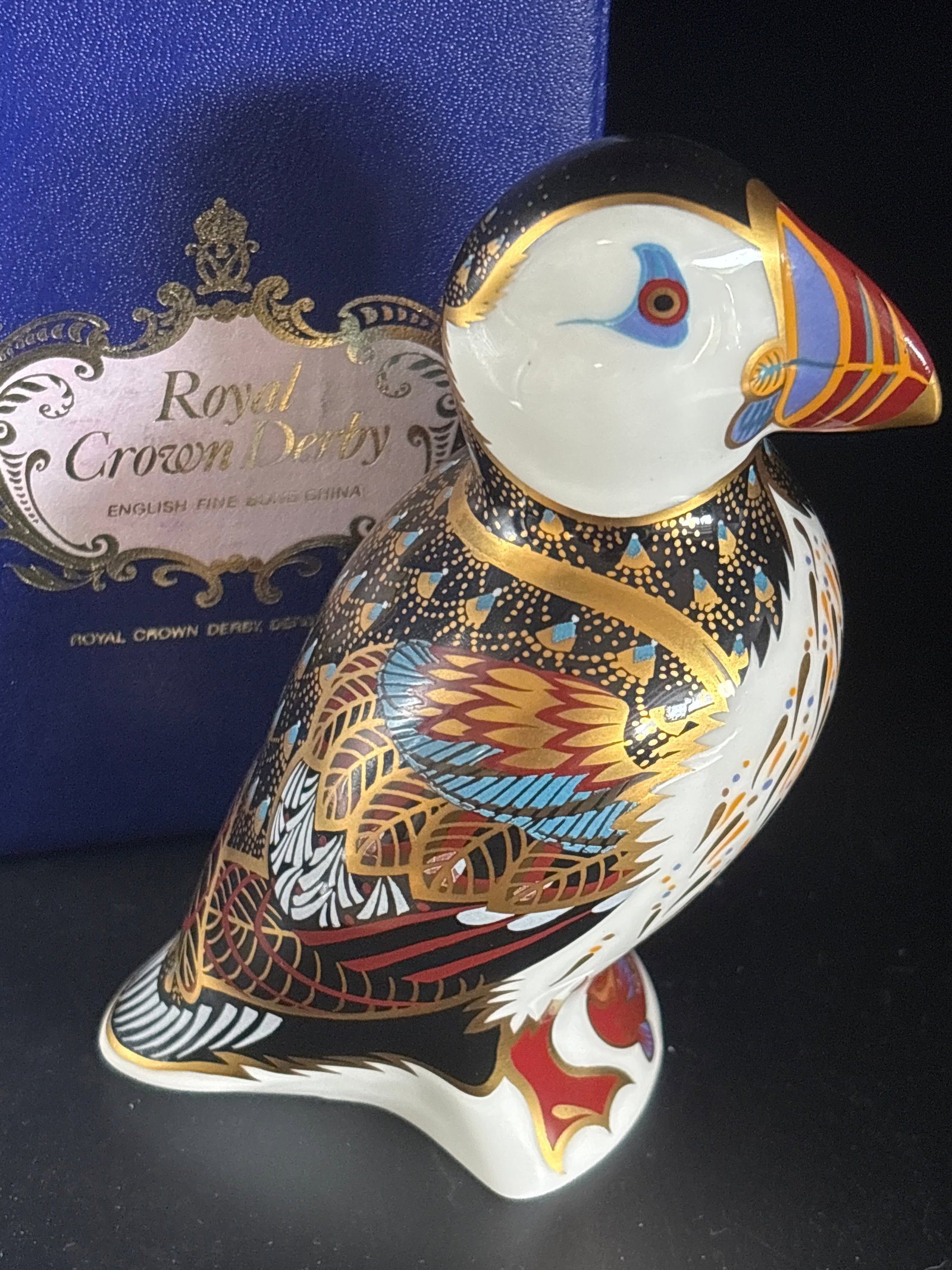 Puffin form Royal Crown Derby fine bone china 4.5 in h paperweight: Gold stopper with box. Royal Crown Derby Puffin Paperweight, a highly collectible piece crafted from fine English bone china.OverviewIntroduced in 1996 and retired in 2022, this figurine features Roya