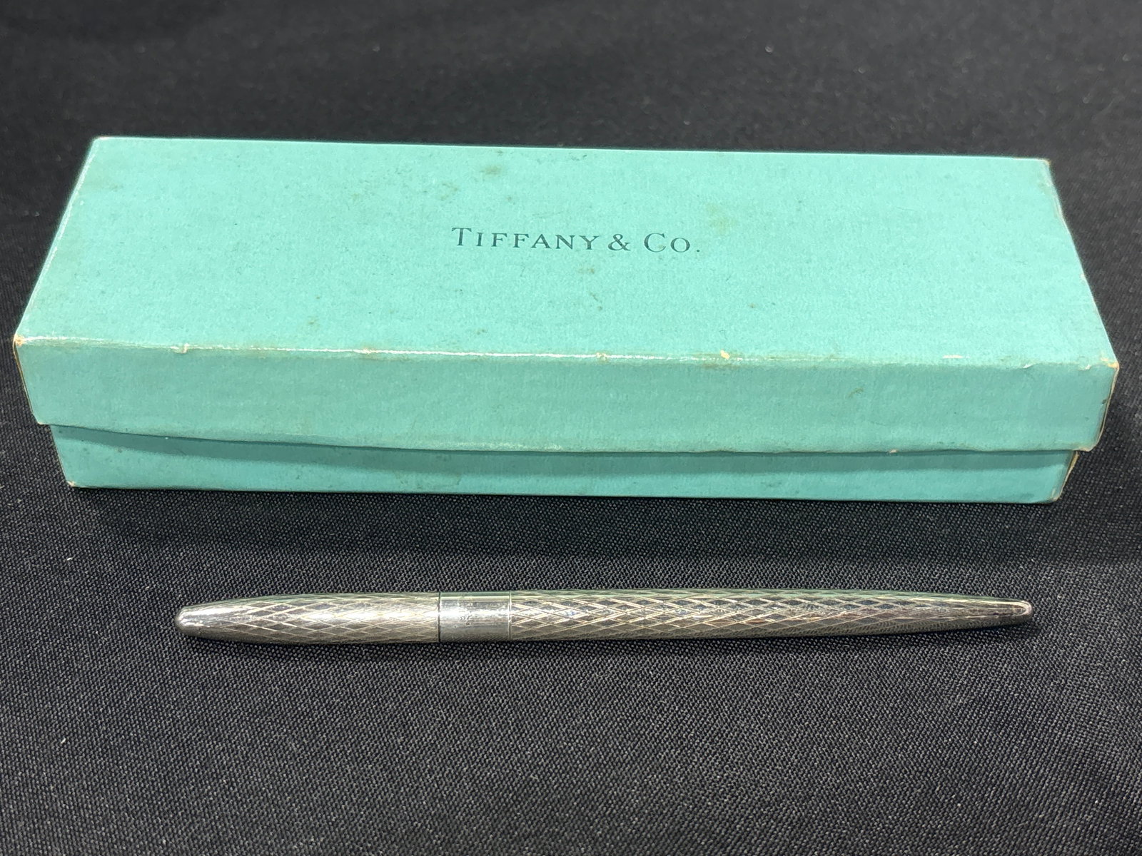 vintage Tiffany & Co. sterling silver ballpoint pen in box: vintage Tiffany & Co. sterling silver ballpoint pen, likely featuring a textured diamond pattern on the barrel. Brand: Tiffany & Co.Material: Sterling Silver (marked "925" or "Sterling").Design: Often