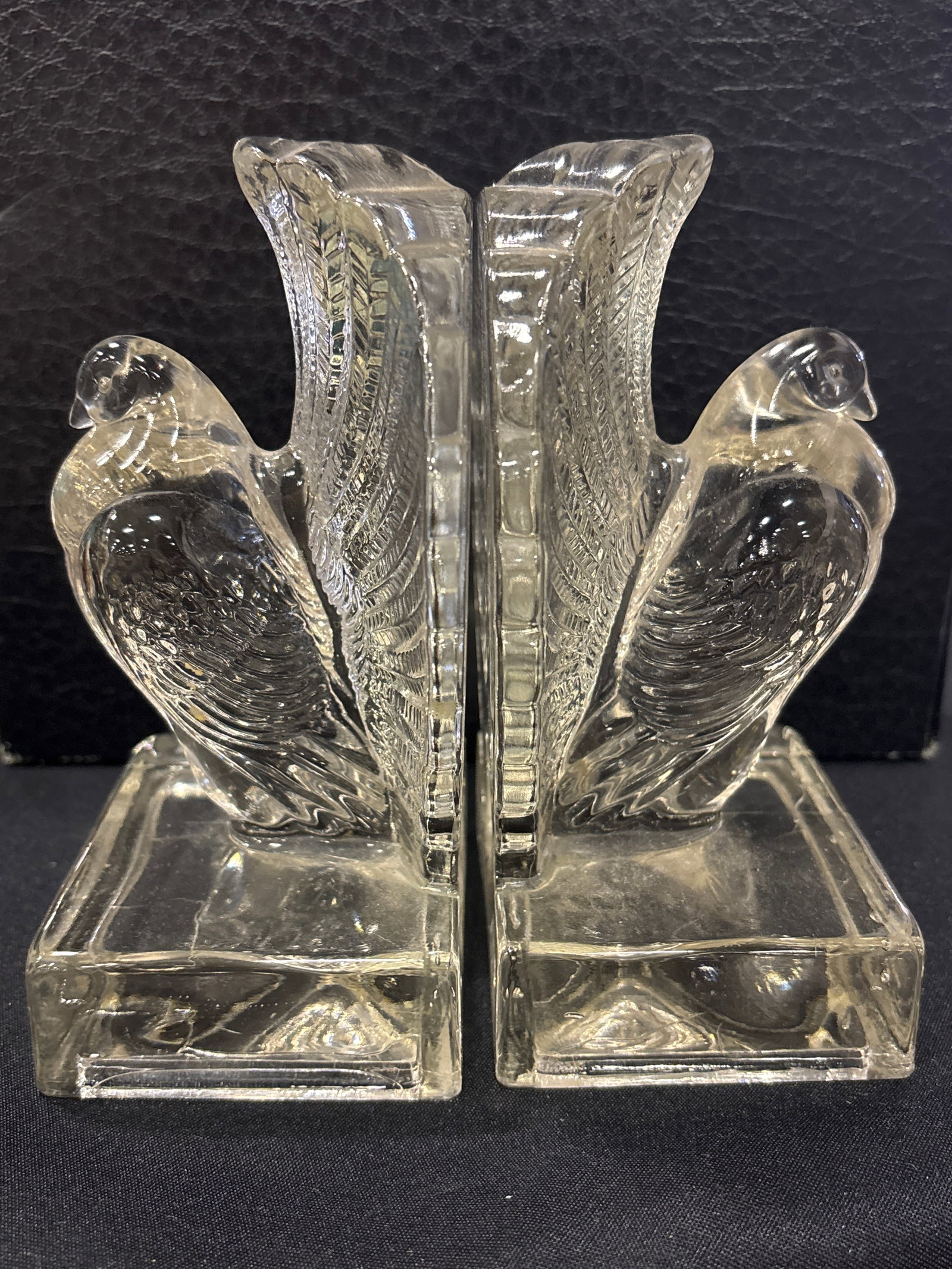 Pair vintage Indiana Glass Co. pouter pigeon form bookends: Pair vintage Indiana Glass pouter pigeon bookends. Material: Clear molded glass.Design: Features a detailed pigeon bird design on a rectangular base.Era: Typically attributed to the 1970s