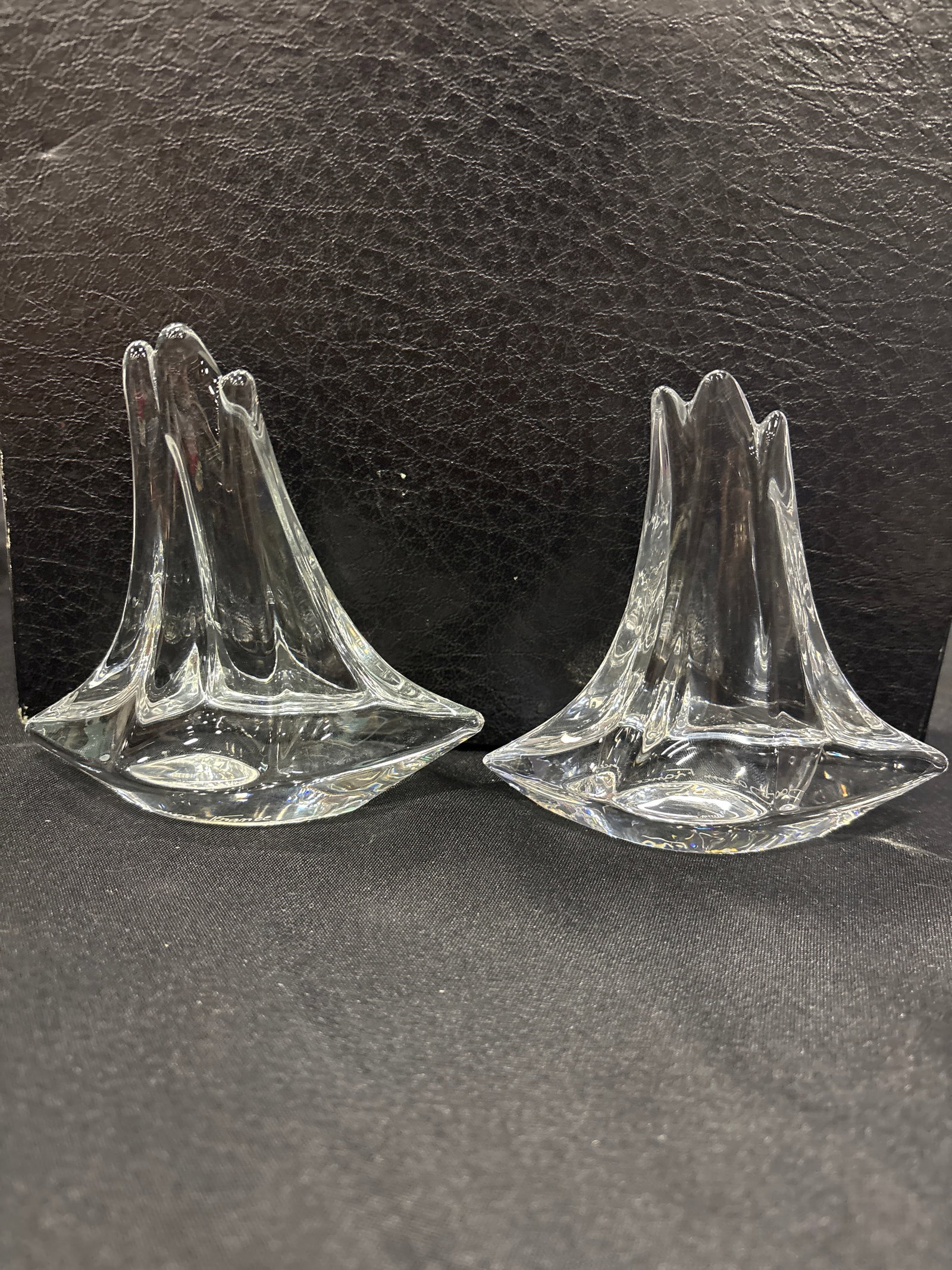 Two signed Daum France crystal glass sailboat sculptures with boxes: Two Daum France crystal glass boat figurines, a collectible art glass piece featuring a clear, streamlined design and the brand's signature marking. Brand: Daum FranceMaterial: Clear Crystal GlassItem
