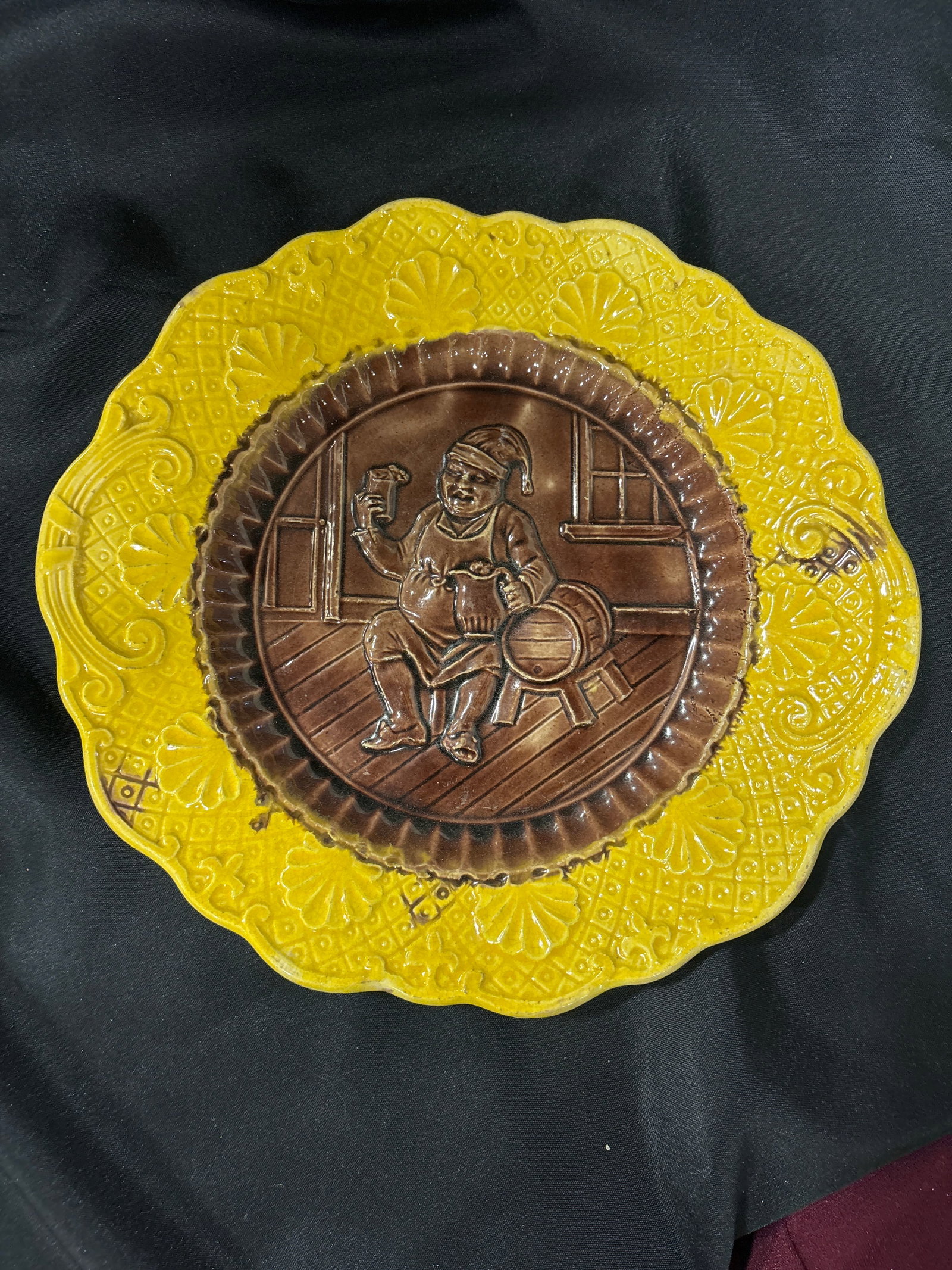 antique ‘Toby Man’ Majolica brown & yellow glaze ceramic plate: antique Majolica ceramic plate, specifically identified as a German Beer Drinker plate featuring a man in relief holding a pint. Style: Whimsical Victorian-era majolica, often featuring mottled colore
