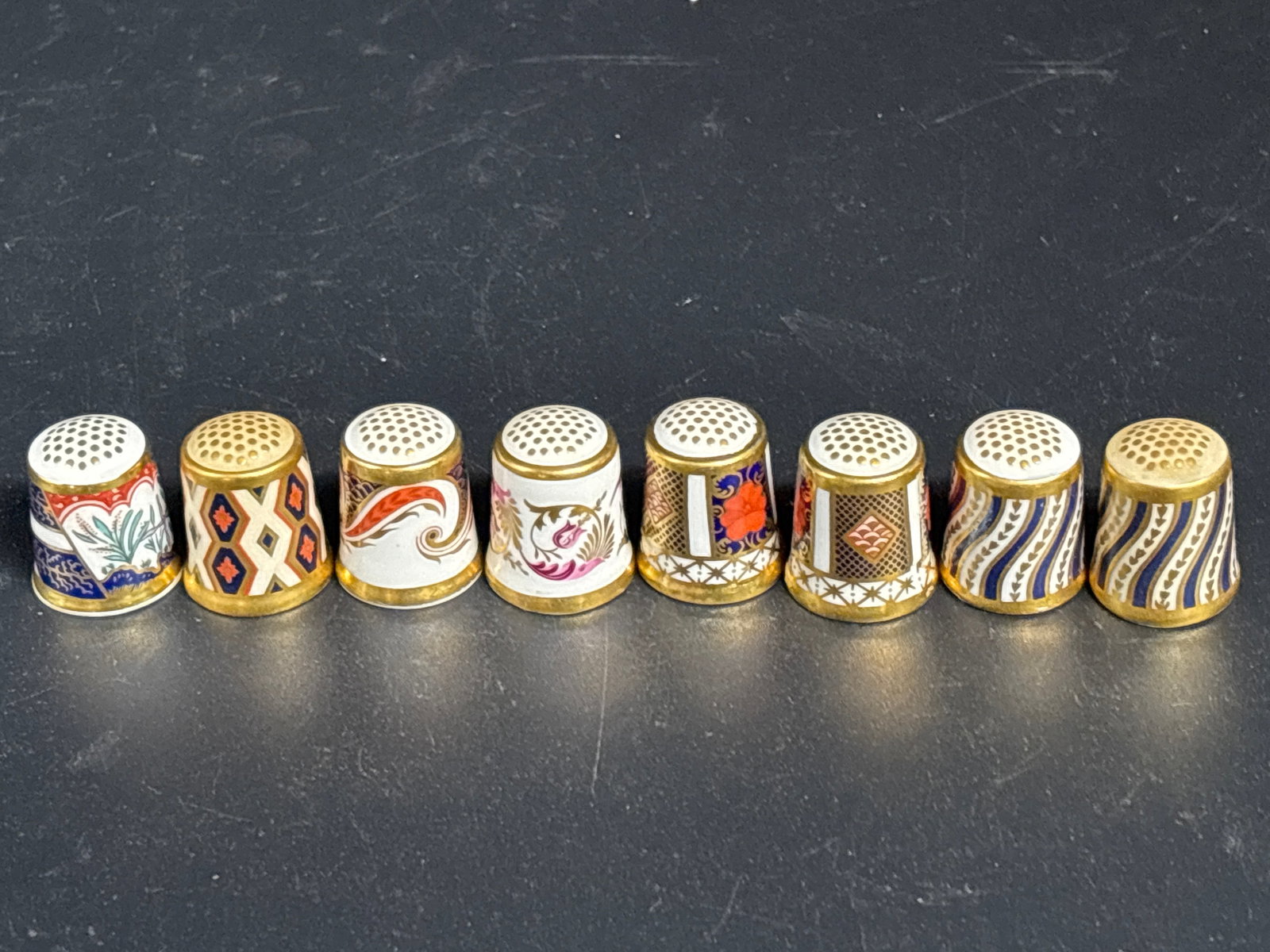 Group of eight assorted vintage Royal Crown Derby porcelain thimbles: Group of eight assorted vintage Royal Crown Derby porcelain thimbles, featuring intricate decorative patterns such as the traditional Imari style. Brand: Royal Crown Derby. Material: Fine Bone China. 