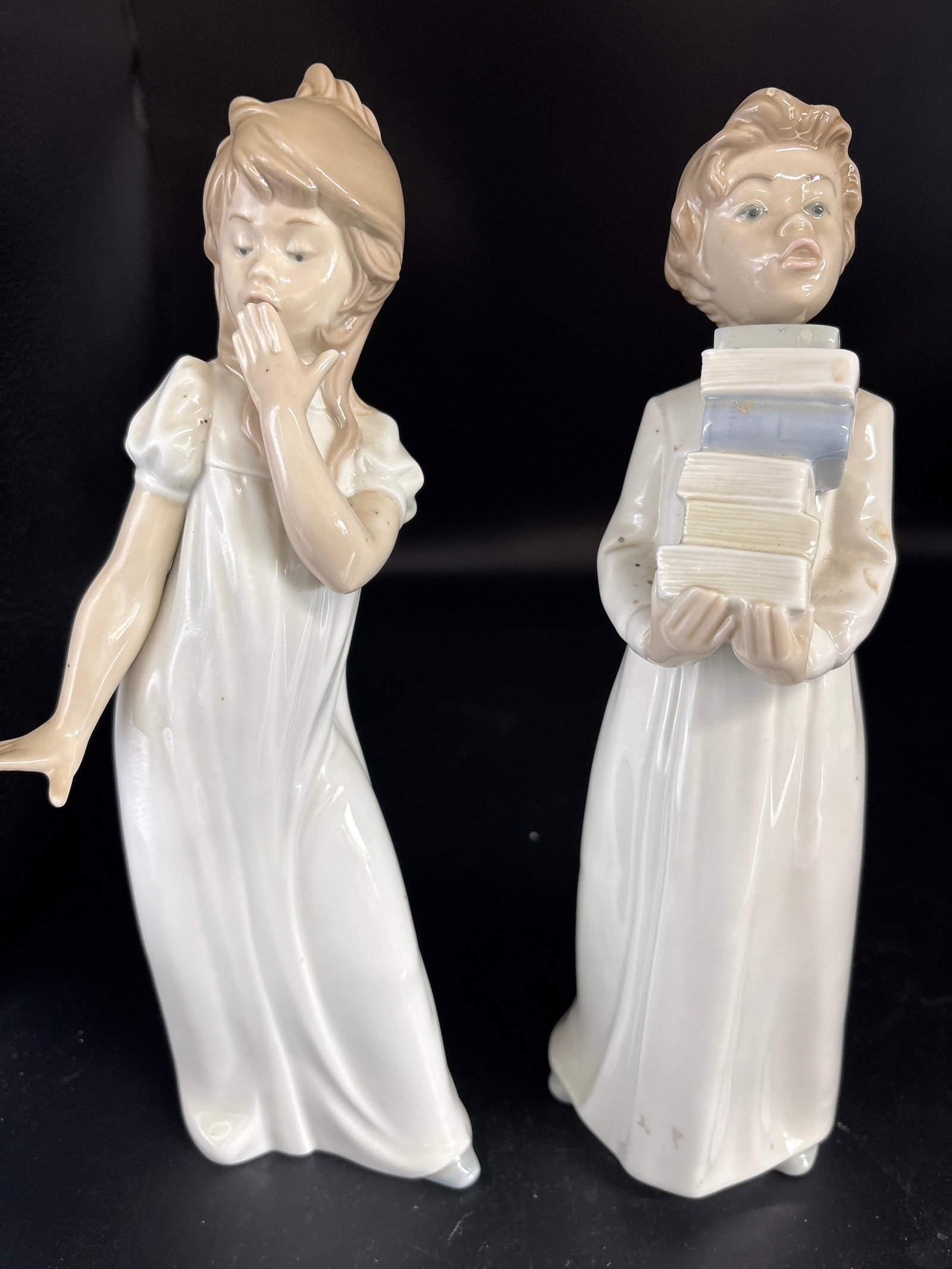 Two large 11 inch Nao by Lladro handmade Spanish porcelain figurines: Two large 11 inch Spanish porcelain figurines from the NAO collection by Lladró, produced in Spain. The figurine on the left is titled "Young Girl Yawning". The figurine on the right depicts a child 