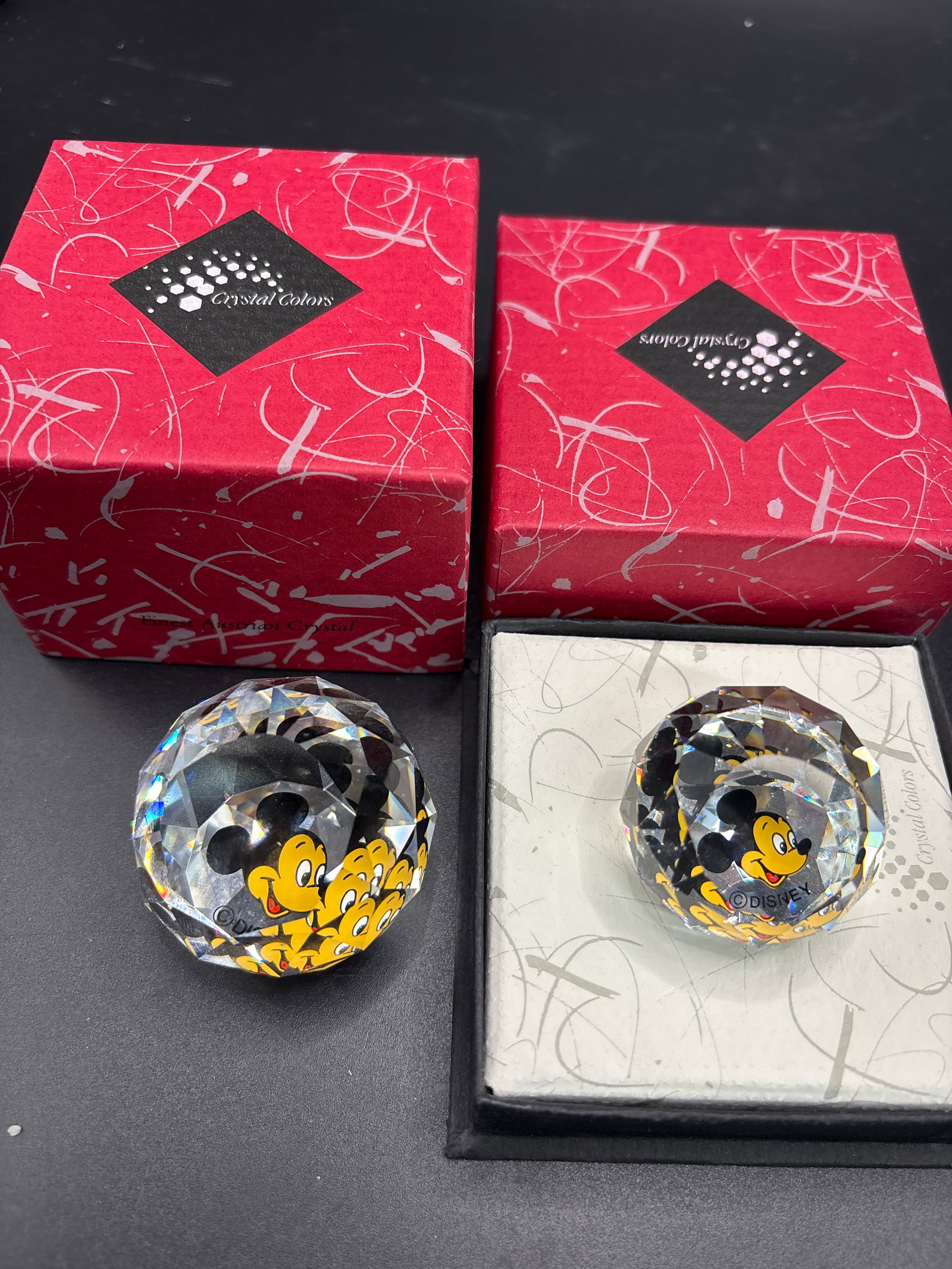 Two Swarovski Disney Mickey Mouse crystal ball paperweights: Two Swarovski Disney Mickey Mouse crystal ball paperweights, featuring a faceted design and an image of Mickey Mouse inside. Manufacturer: Swarovski Character: Disney's Mickey Mouse Design: Faceted