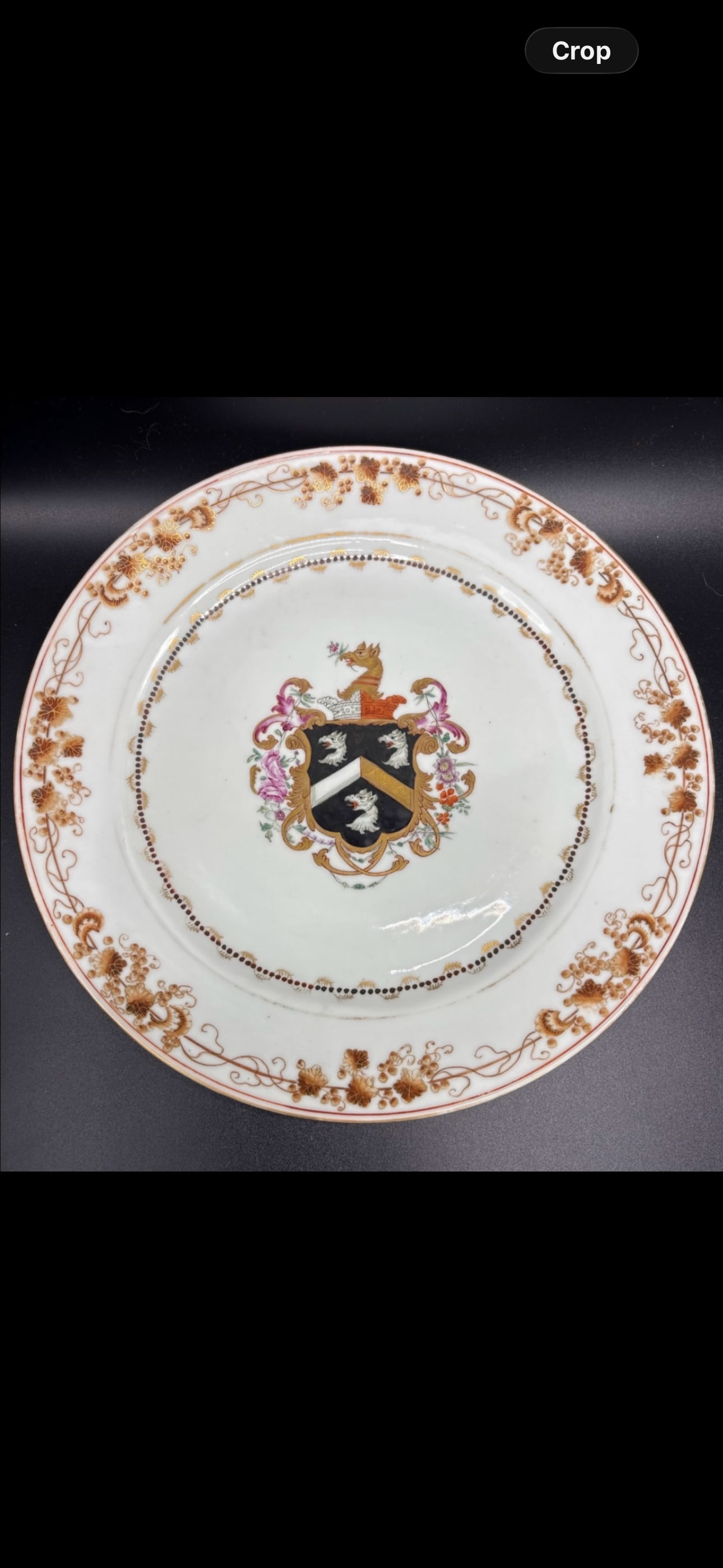 18th-century Chinese export armorial porcelain plate featuring a central coat of arms: 18th-century Chinese export armorial porcelain plate featuring a central coat of arms. Design: The plate is adorned with a central heraldic shield depicting a black chevron accompanied by three heads 