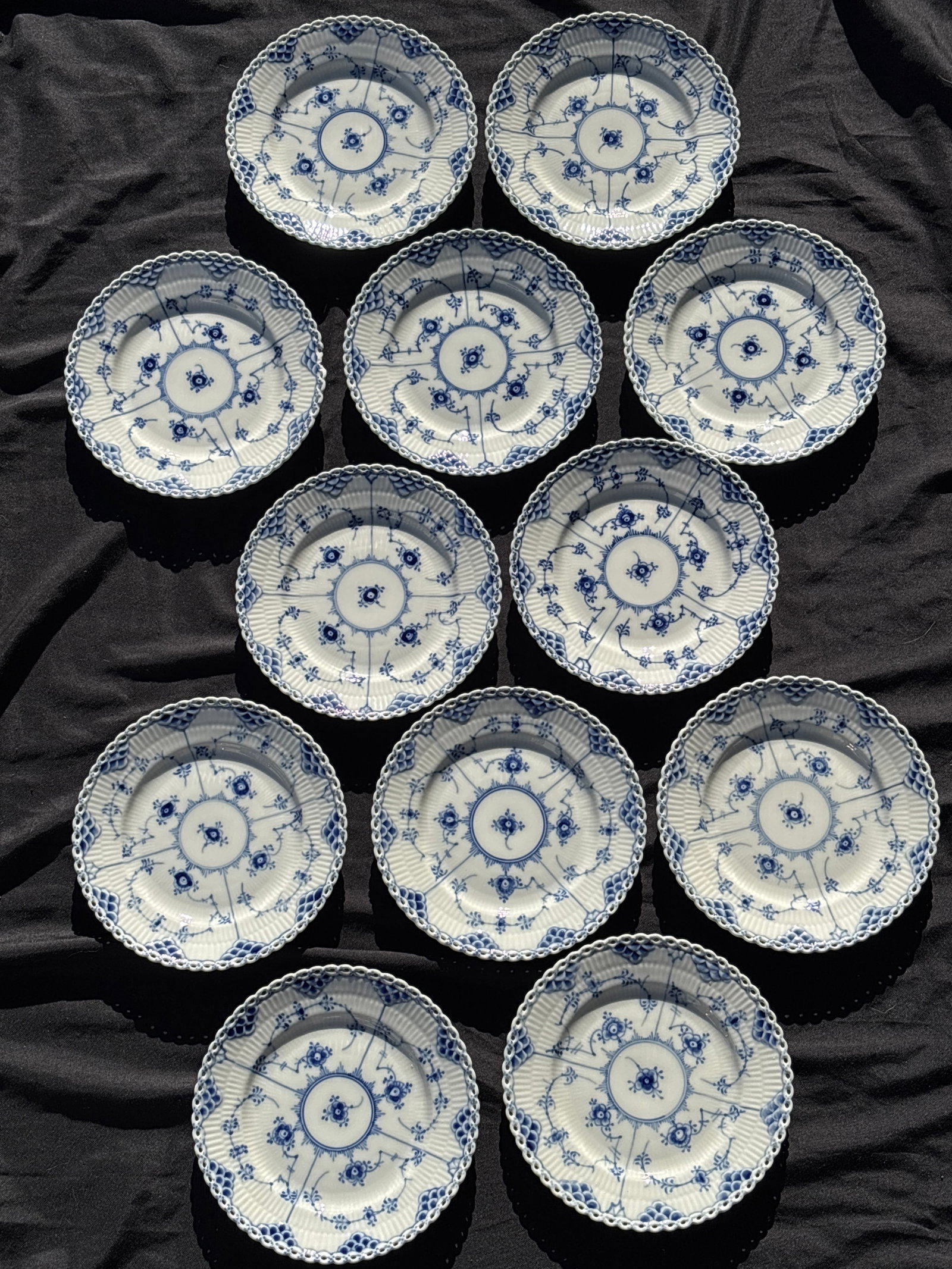 Set of twelve Royal Copenhagen Blue Fluted Full Lace6&7/8 inch plates#1087: Set of twelve 6&7/8 inch Royal Copenhagen Blue Fluted Full Lace plates, a prestigious line of Danish porcelain.Key FeaturesIntricate lace-like rim with delicate perforations.Hand-painted cobalt blue f