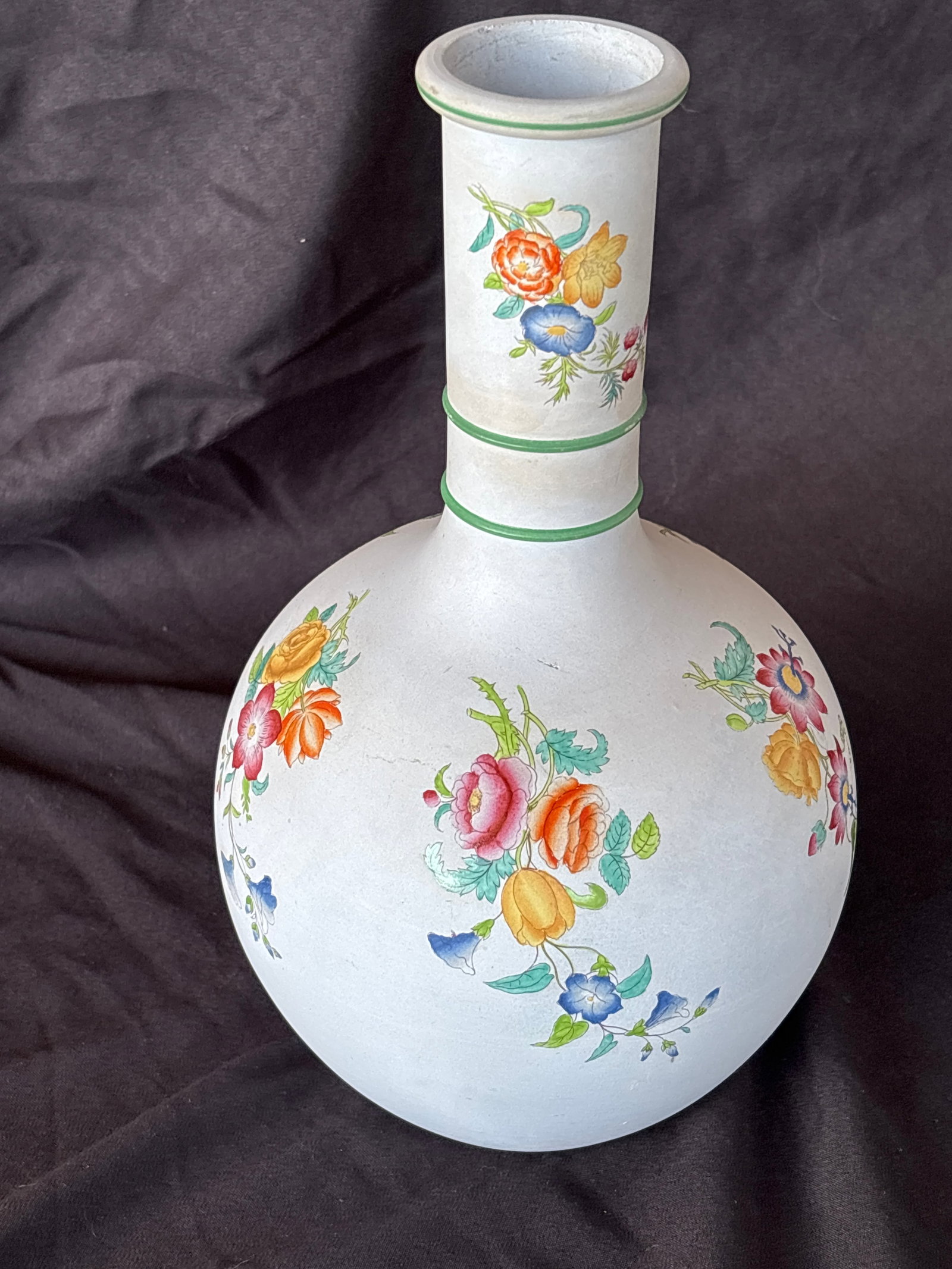 .antique Copeland porcelain bottle form 10 inch vase: .antique Copeland porcelain bottle vase, British origin, featuring hand-painted floral motifs and green trim.Design Details: The vase has a slender neck tapering down to a broad, bulbous body, a shape