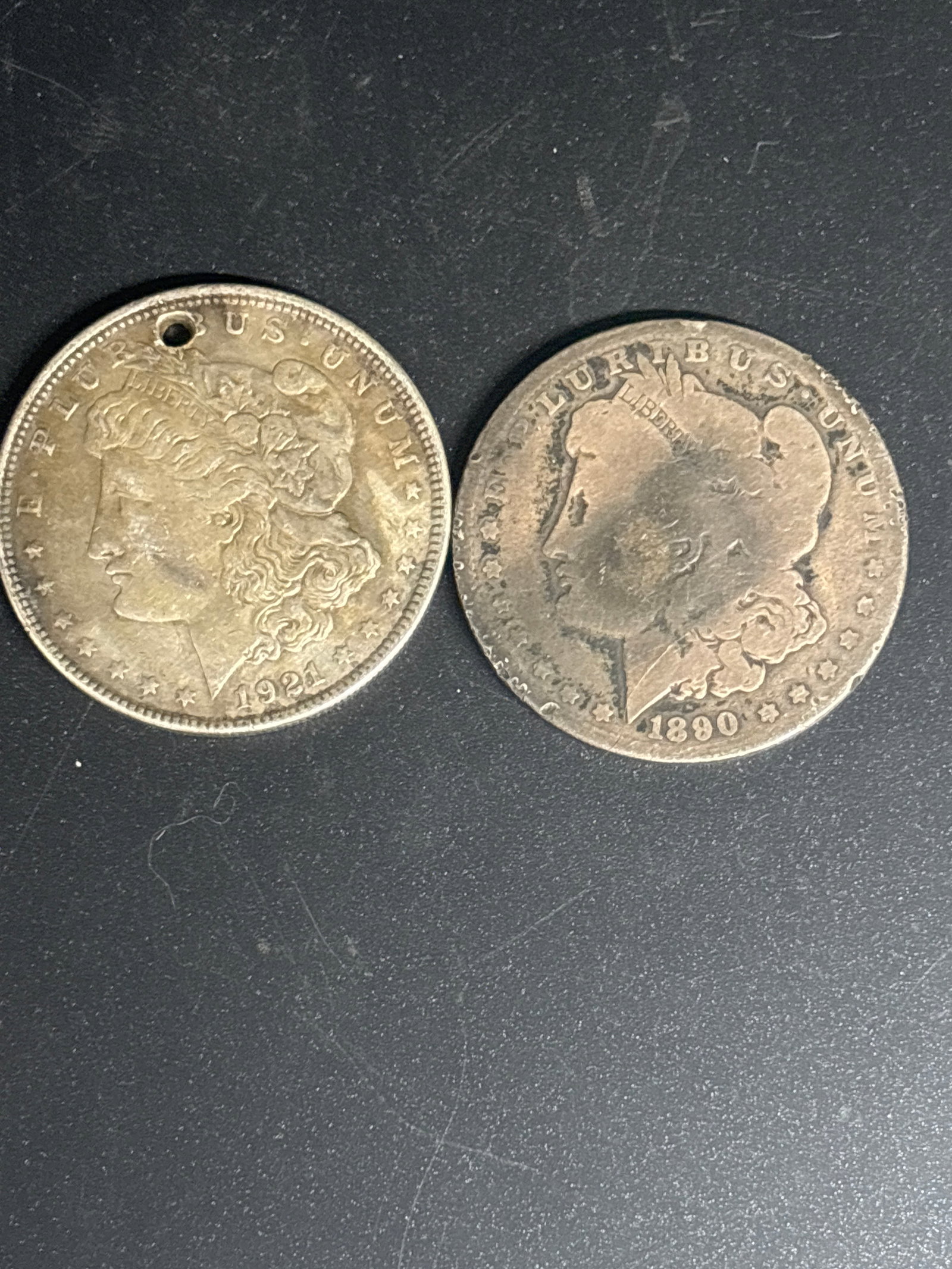 Two Authentic Morgan United States Silver Dollar.1890&1921(holed): . Two Authentic Morgan United States Silver Dollar.1890&1921(holed Composition: It is made of 90% silver and 10% copper.Design: Morgan silver dollar.Composition: These coins are made of 90% silver and