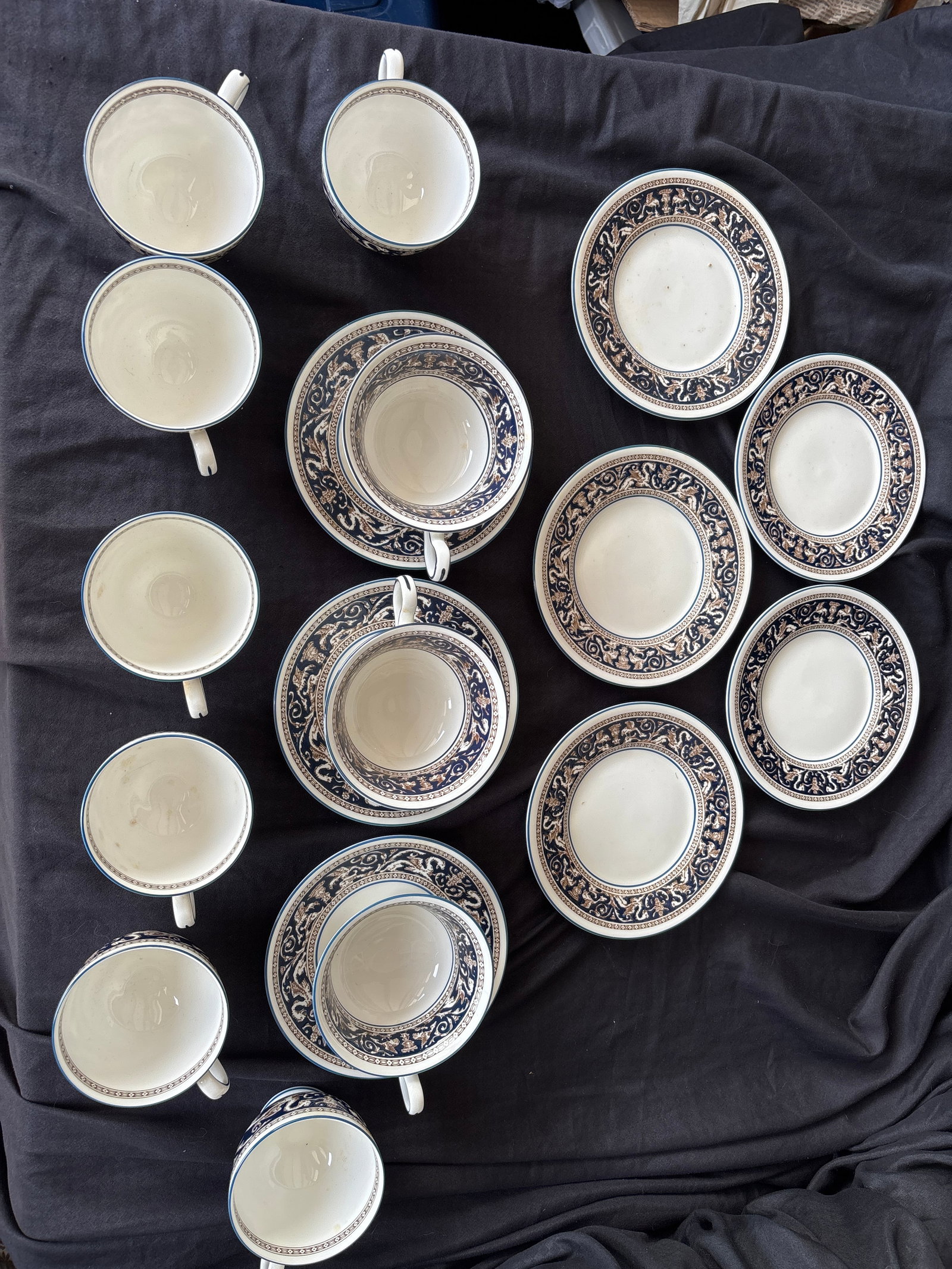 19 piece bowls Wedgwood Florentine Dark Blue (W1956): Five 6 inch plates, three teacups with saucers and seven small cup.; Wedgwood Florentine Dark Blue (W1956) pattern. This classic design is crafted from fine bone china and features a rich cobalt/navy 