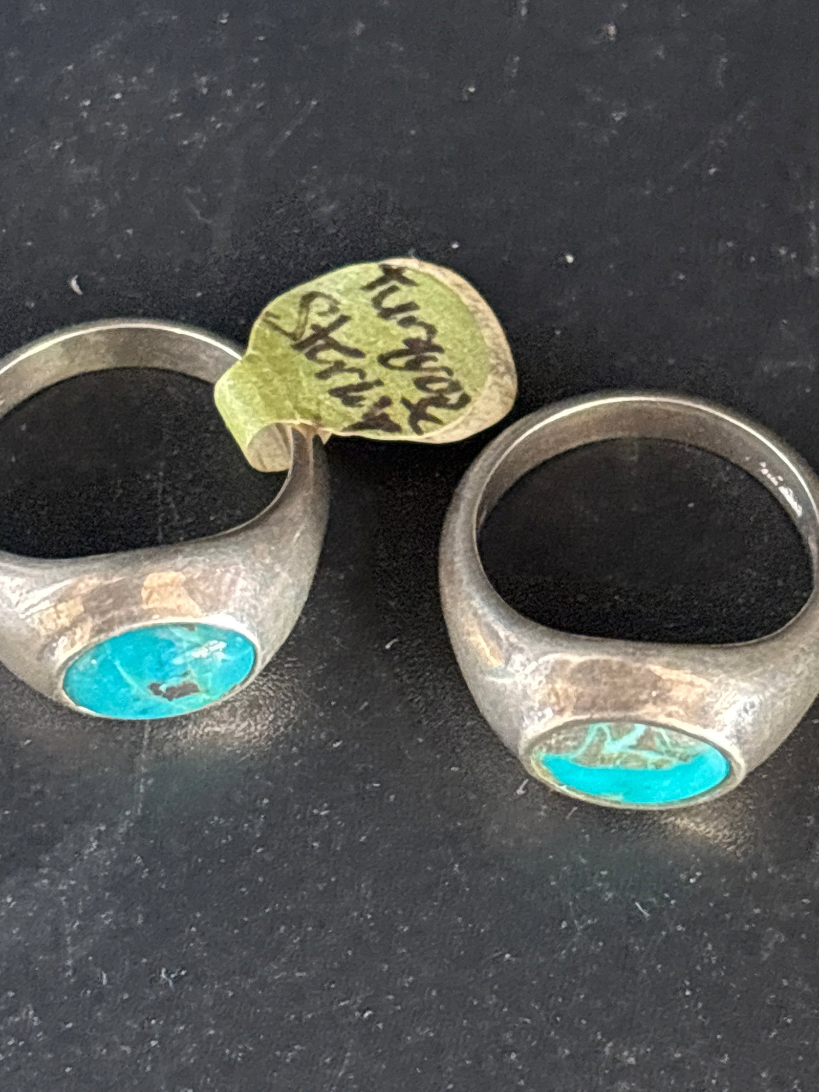 Two turquoise signet rings crafted from solid sterling silver: Two turquoise signet rings crafted from solid sterling silver. These rings typically feature an oval-cut turquoise gemstone inset into a smooth, polished silver band.Features and IdentificationMateria