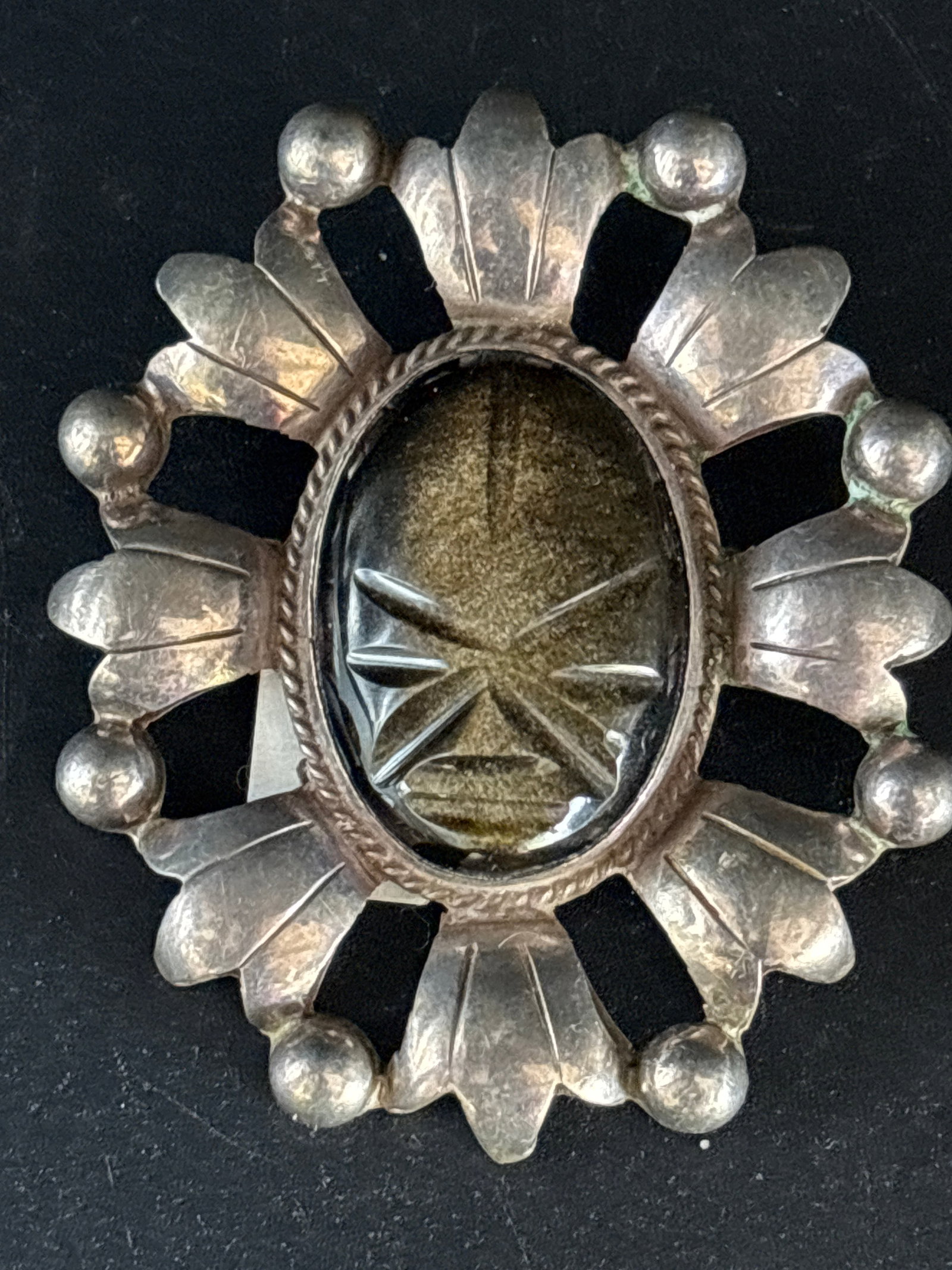 large 2&1/2 inch Mexican sterling silver brooch pin Taxco creation; 20 grams: Mexican silver piece, possibly a Taxco creation from the mid-20th century. The central stone appears to be carved obsidian or jade, featuring a stylized face or mask typical of Mexican "Aztec" or "May