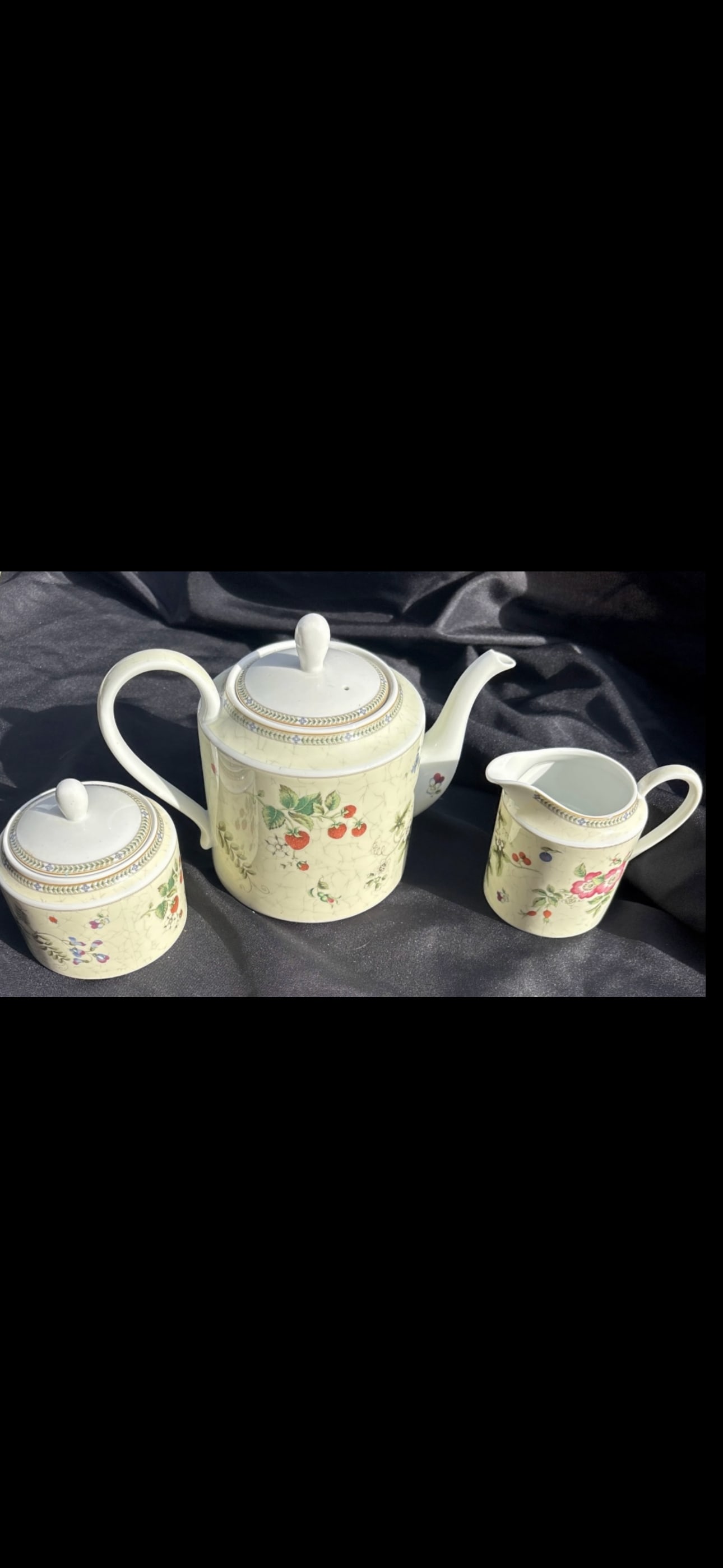 Three piece Wedgwood Fleur pattern tea set: Three piece tea set Wedgwood the Fleur pattern.Pattern DetailsThe Fleur pattern features a delicate design of pink and white flowers along with various fruits, including strawberries on vines, blueber