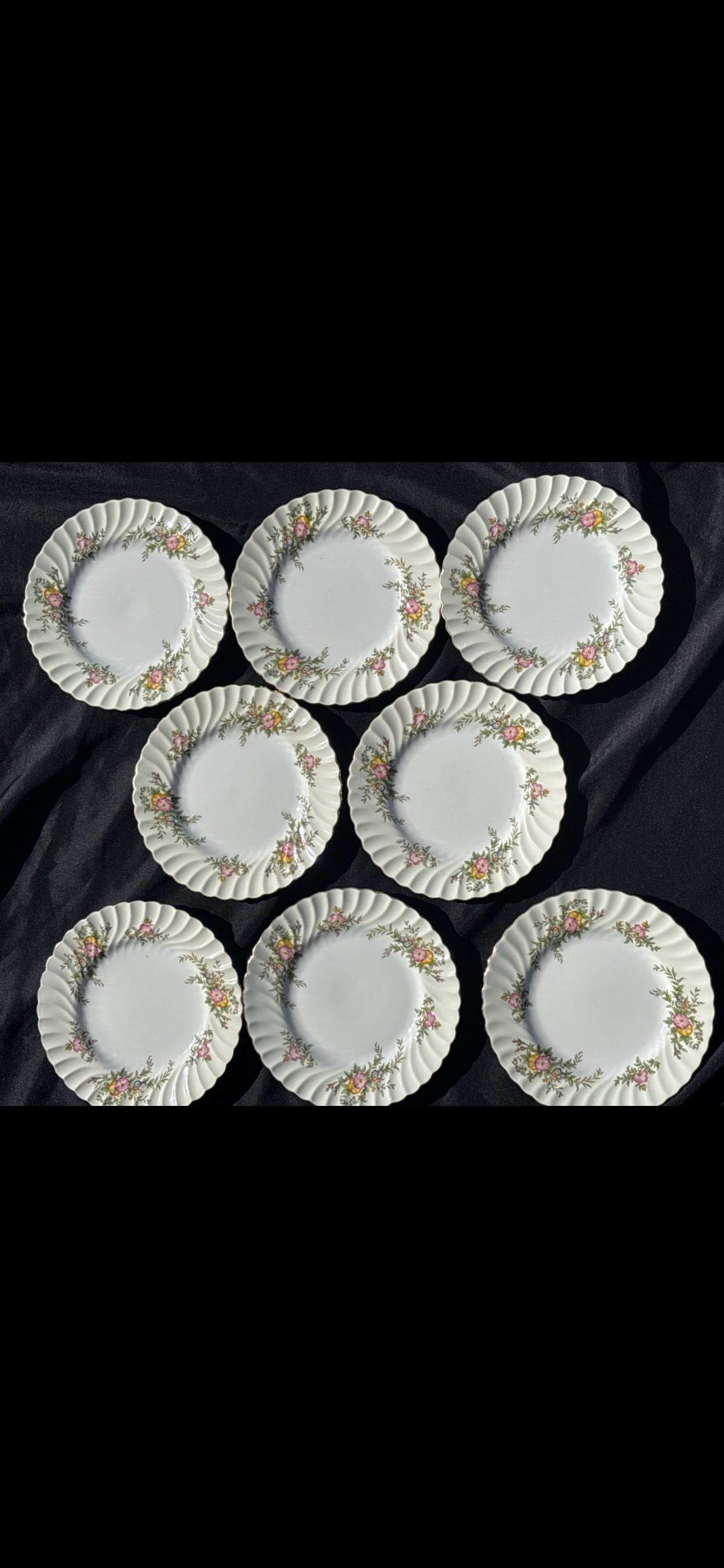 Eight 7&3/4 inch plates Minton English fine bone china ‘York’ (number S501): Eight 7&3/4 inch plates vintage Minton bone china in the "York" pattern (number S501), manufactured in England between 1941 and 1969. Design: Features a swirled rim with pink and yellow floral sprays 