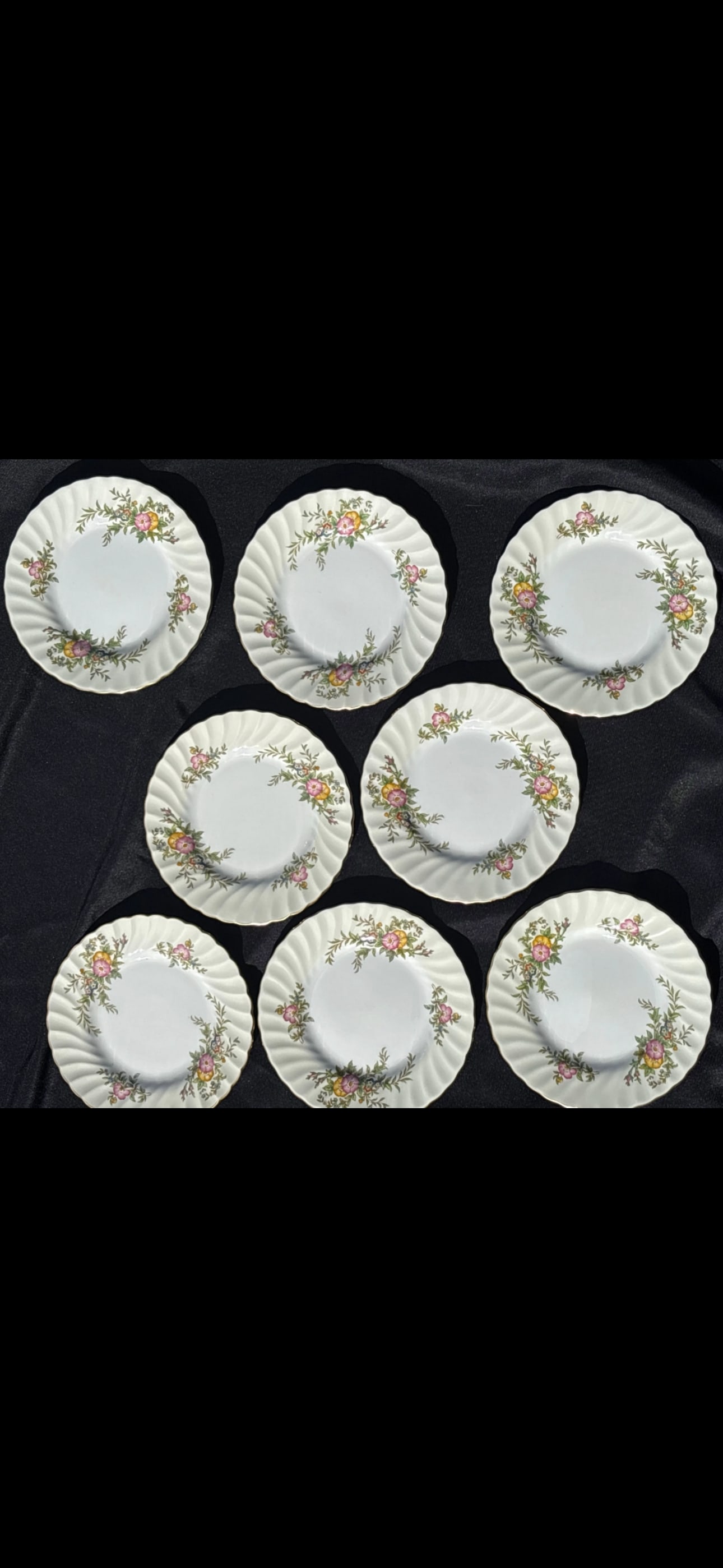 Eight 6&1/4 inch plates Minton English fine bone china ‘York’ (number S501): Eight 6&1/4 inch plates vintage Minton bone china in the "York" pattern (number S501), manufactured in England between 1941 and 1969. Design: Features a swirled rim with pink and yellow floral sprays 