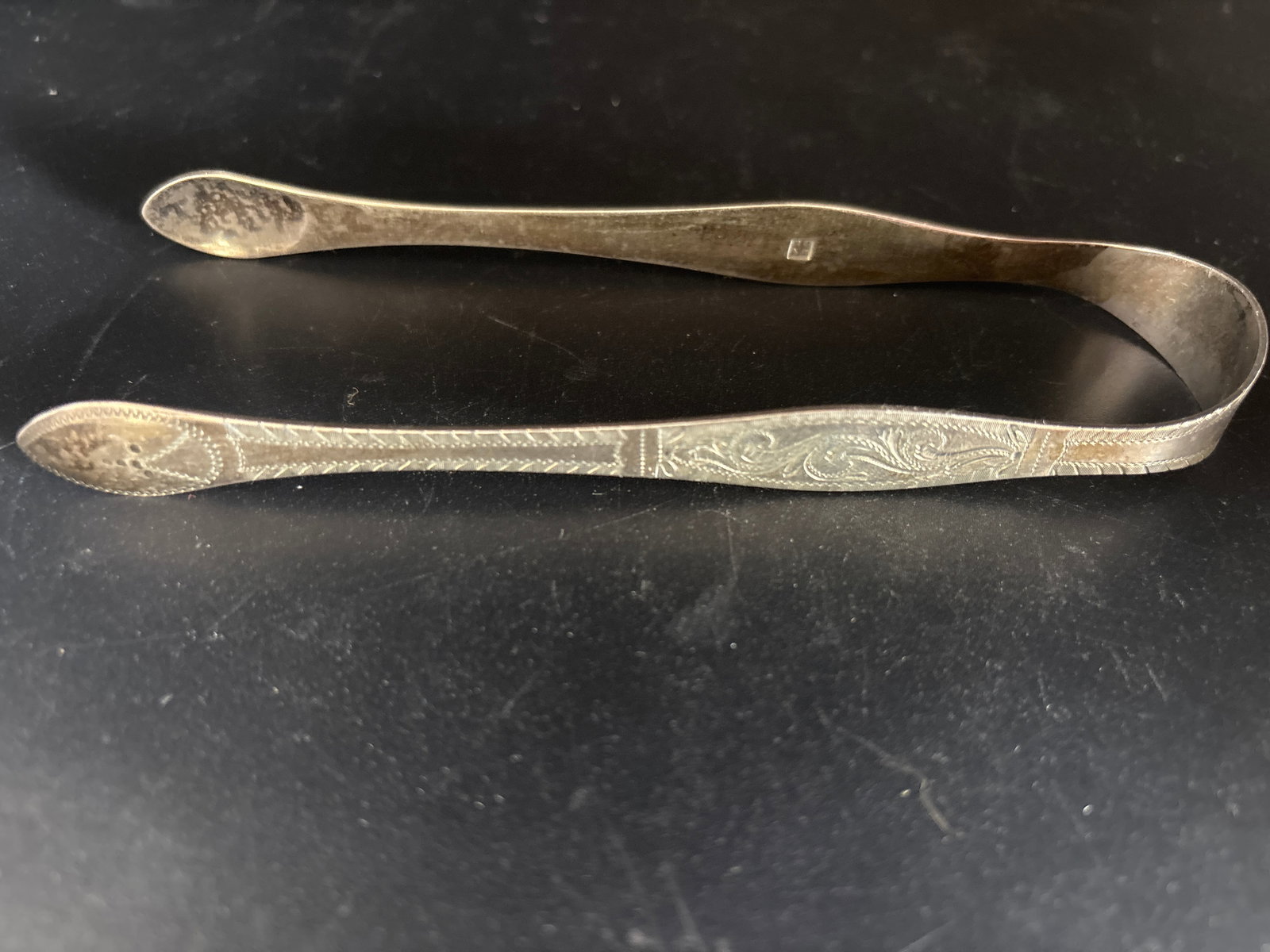 Georgian era English hallmarked sterling 5&5/8 inch tongs; 32 grams: 32 grams.antique sterling silver sugar tongs, likely dating from the Georgian era (late 18th to early 19th century) and often featuring intricate "bright-cut" engraving.Maker Identification: They freq