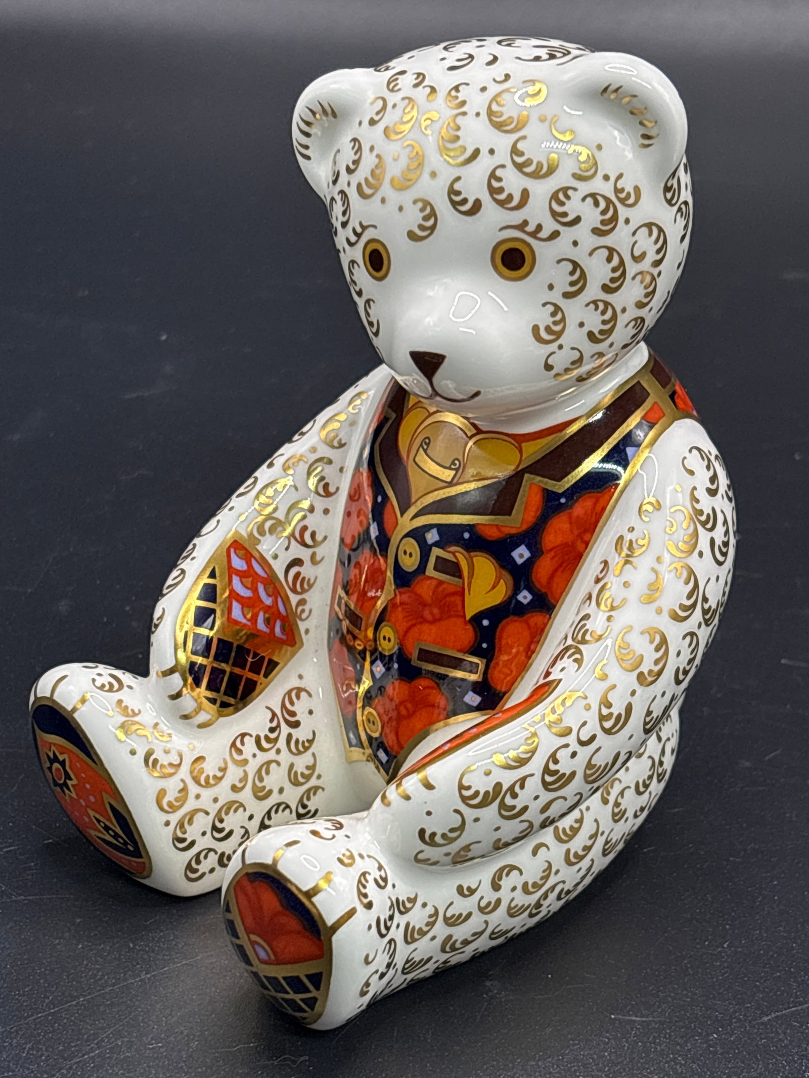 1997 Royal Crown Derby "Debonair Bear" 4&1/2 inch paperweight statue: Royal Crown Derby "Debonair Bear" paperweight, featuring a classic Imari color palette of red, blue, and gold.The figurine is made of fine bone china and often includes a gold stopper underneath to de