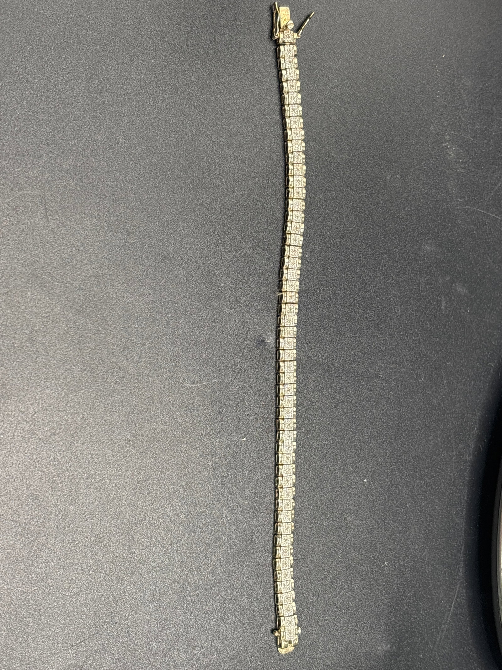 Vintage .925 silver classic square-link tennis bracelet; 17 grams: classic square-link tennis bracelet, featuring a continuous line of closely set gemstones. While it has a warm tone characteristic of gold, many sterling silver options feature yellow gold plating (ve