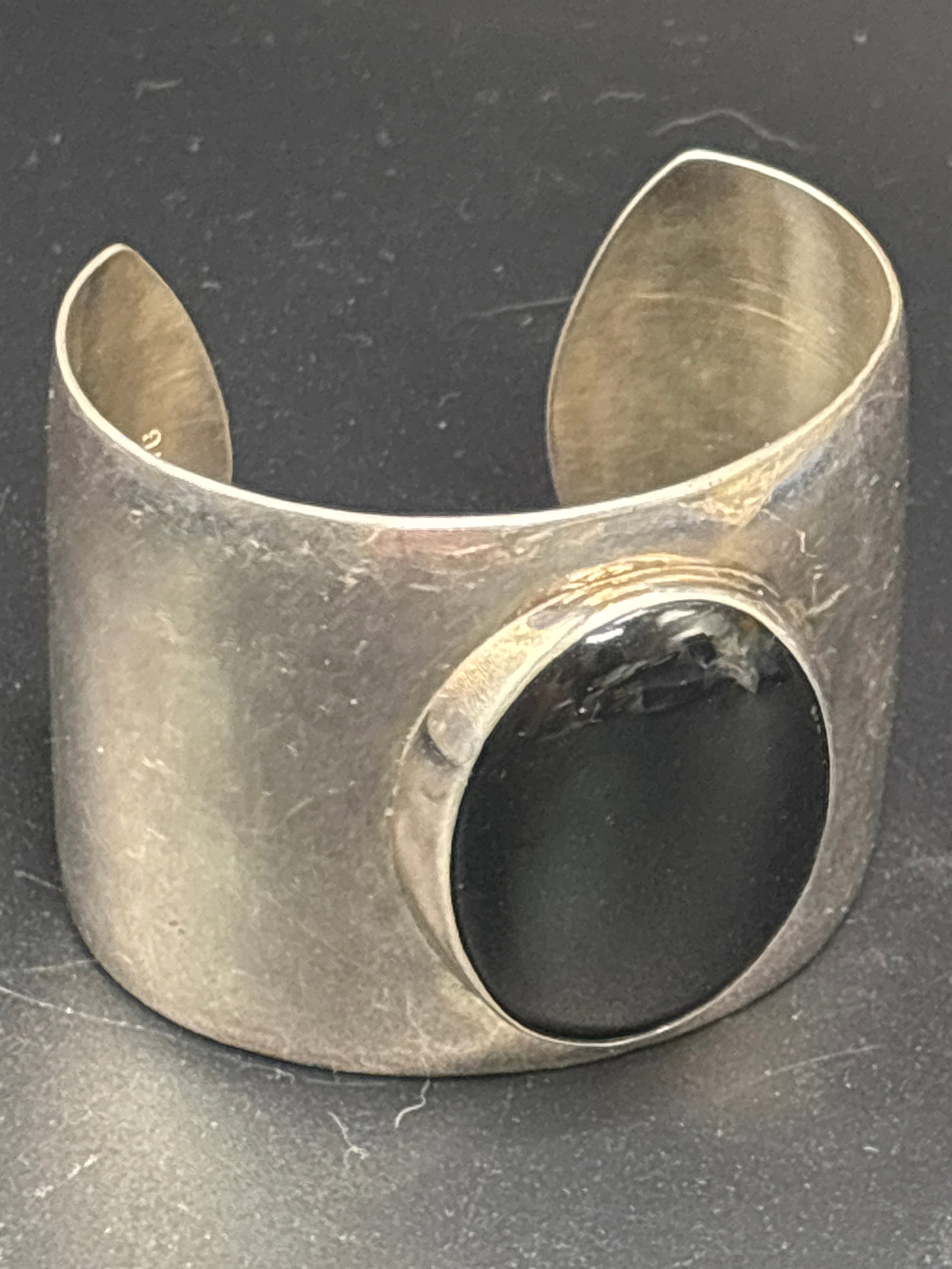 74 grams; Vintage solid 925 sterling cuff bracelet black onyx cabochon: 74 grams; Vintage cuff bracelet is crafted from 925 sterling silver and features a large, oval black onyx cabochon.Similar modernist pieces are frequently marked as being made in Mexico.Comparable vin