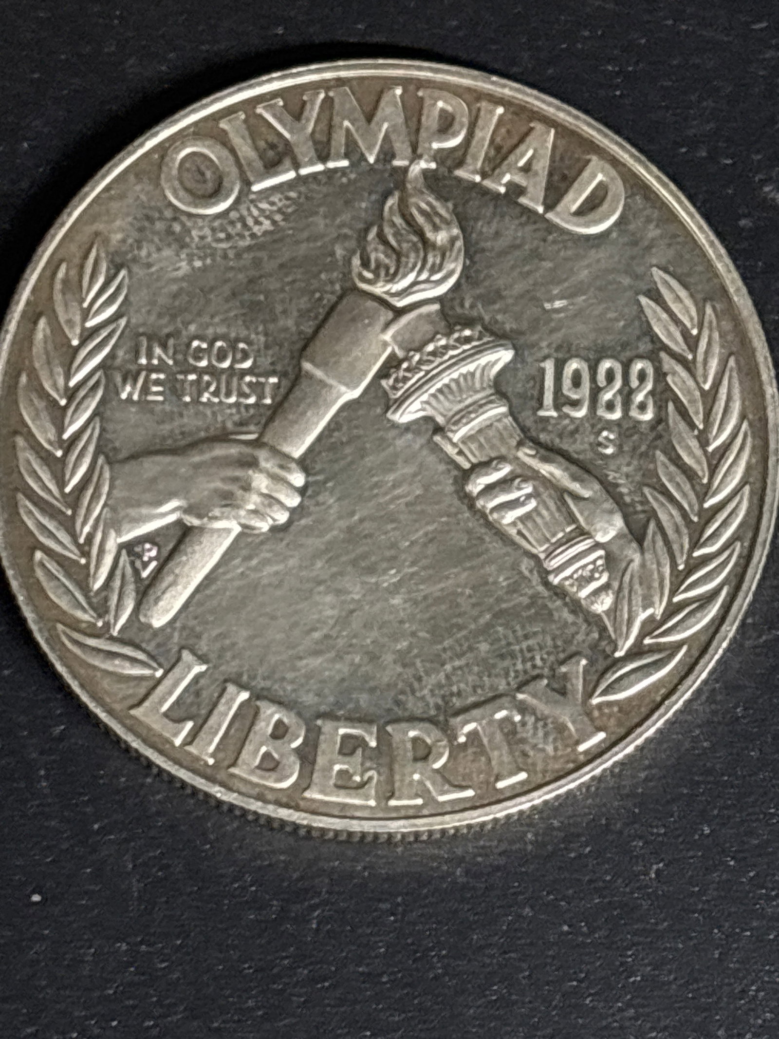 27 grams 90% silver 1988 Summer Olympics United States Commemorative dollar: 1988 United States Olympic Commemorative Silver Dollar.Coin OverviewCommemoration: Issued by the United States Mint to honor U.S. participation in the 1988 Summer Olympic Games held in Seoul, South