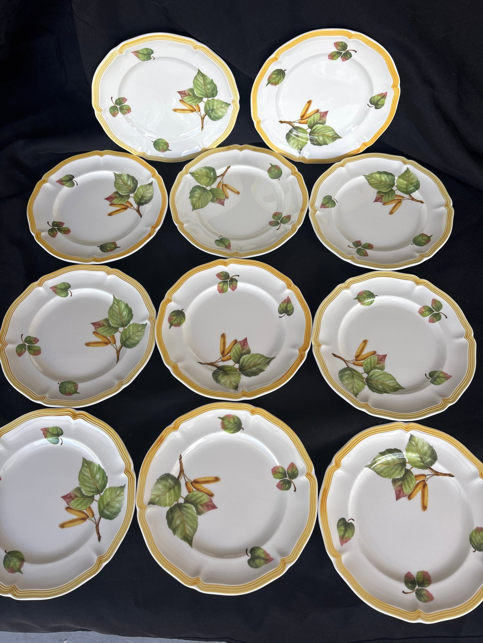 Set of eleven Villeroy & Boch “Parkland” pattern bread & butter plates: Set of eleven Villeroy & Boch “Parkland” pattern bread & butter plates, featuring a distinct yellow rim and botanical leaf design.It is crafted from fine china in Germany and is both