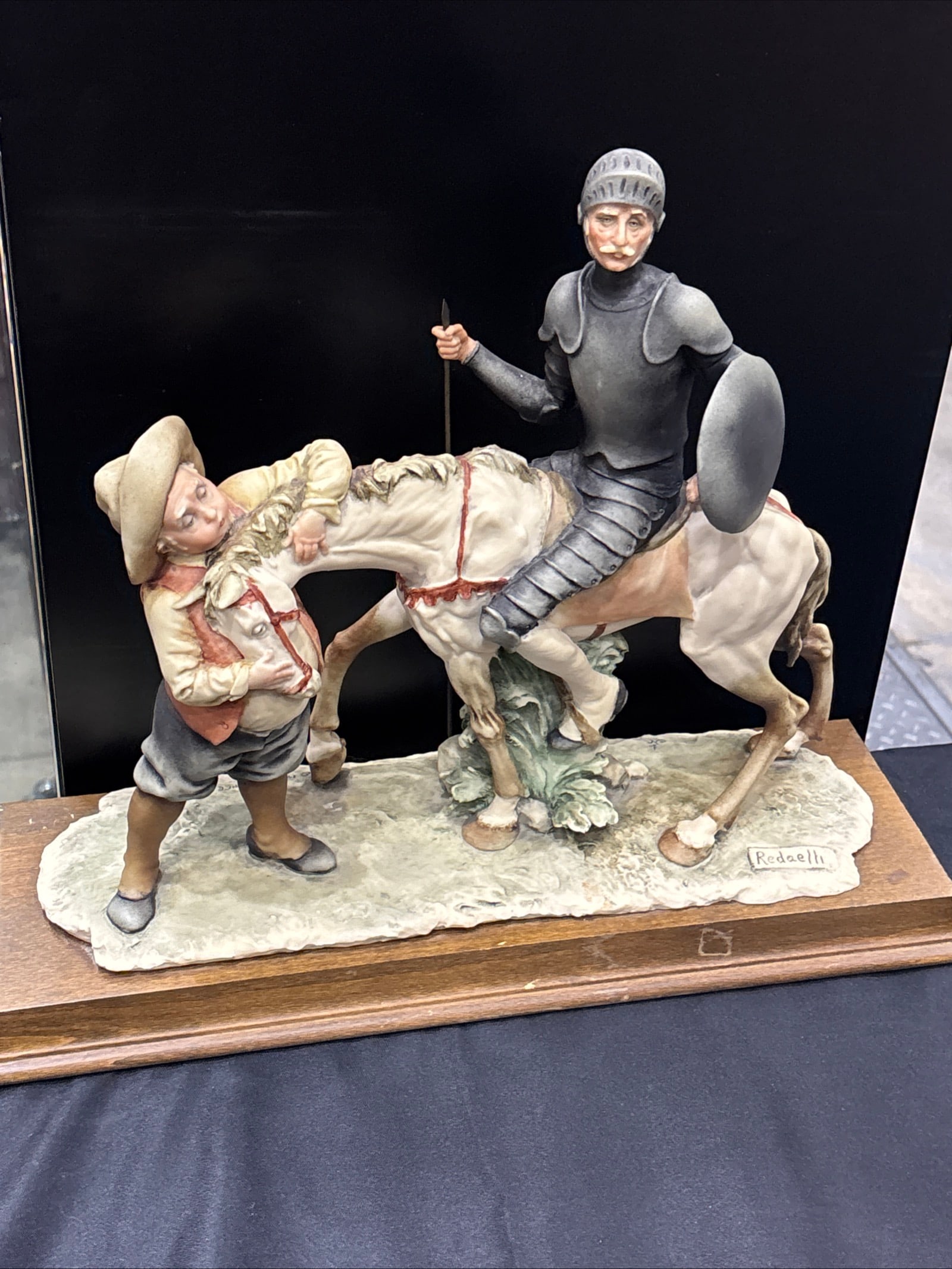 17 inch porcelain figurine of Don Quixote by the artist Redaelli: porcelain figurine of Don Quixote by the artist Redaelli, featuring a hand-painted matte finish.The piece depicts Don Quixote on his horse Rocinante, accompanied by his squire Sancho Panza.It is a lar