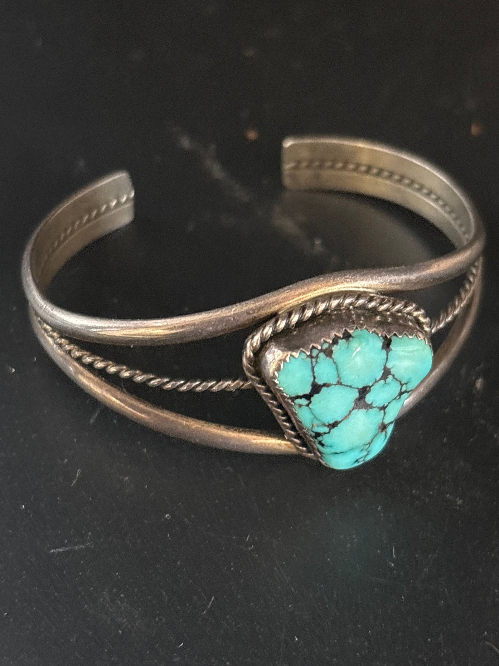 Native American Navajo sterling bracelet features a Dry Creek turquoise stone; 18 grams: Native American Navajo bracelet features a Dry Creek turquoise stone set in sterling silver with a rope twist design.Style: Native American Navajo cuff bracelet.Material: Sterling silver.Stone: