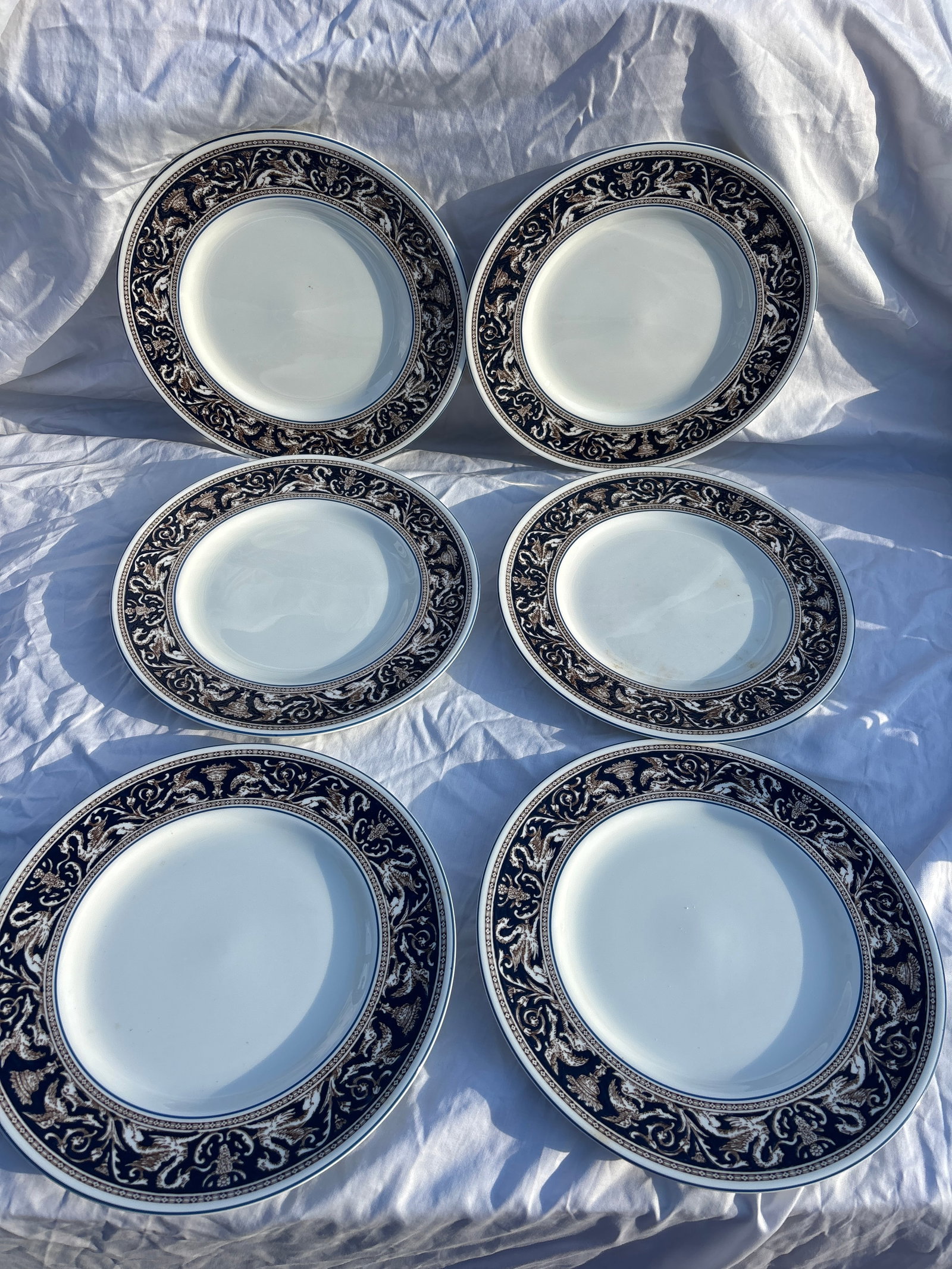 Set of six Wedgwood dinner plate in the Florentine Dark Blue (W1956) pattern: Set of six Wedgwood dinner plate in the Florentine Dark Blue (W1956) pattern.It features a dark blue rim with an intricate dragon and scrollwork design in a contrasting color.The plate is crafted from