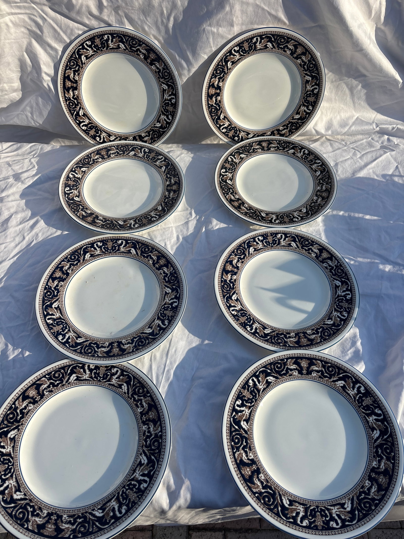 Set of eight Wedgwood plates in the Florentine Dark Blue (W1956) pattern: Set of eight Wedgwood luncheon or salad plate in the Florentine Dark Blue (W1956) pattern.It features a dark blue rim with an intricate dragon and scrollwork design in a contrasting color.The plate is