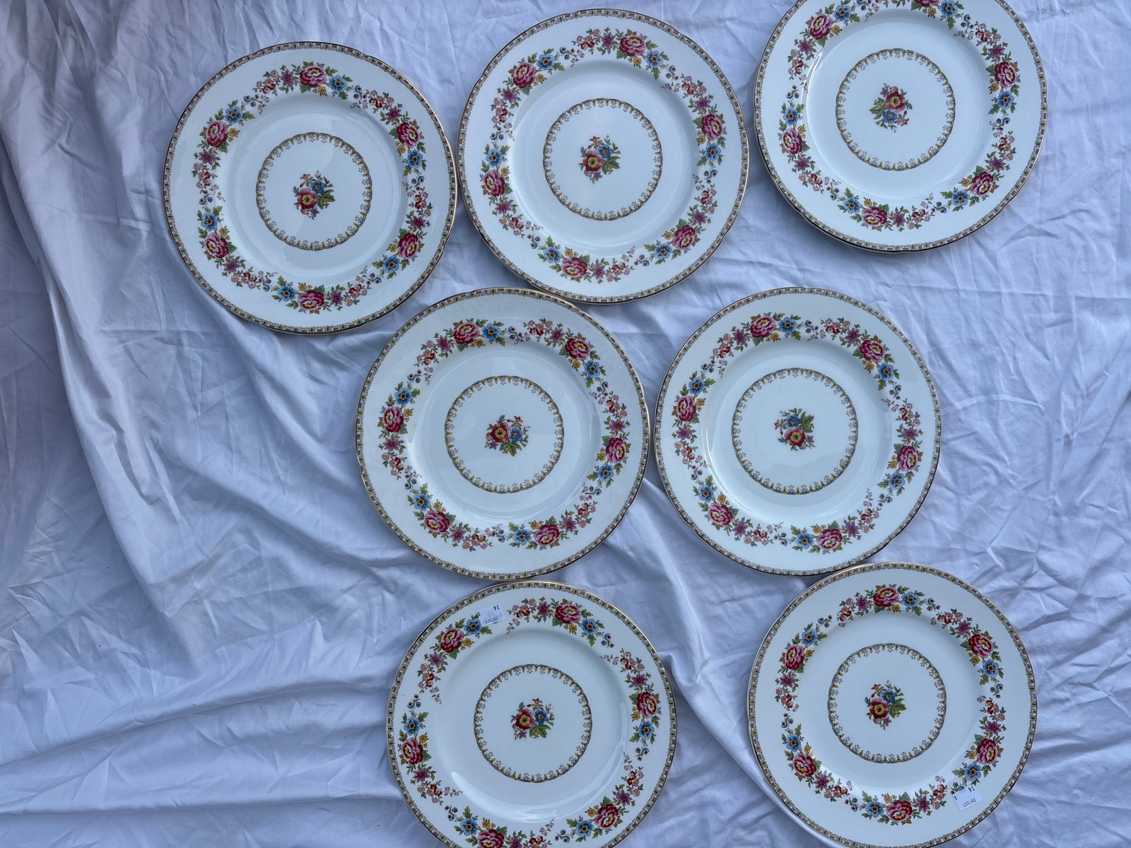Seven vintage Royal Grafton Malvern bone china dinner plates: Seven vintage Royal Grafton Malvern bone china dinner plates, identified by its colorful floral pattern and delicate gilt trim.Crafted in England, this pattern features vibrant multi-colored flowers a