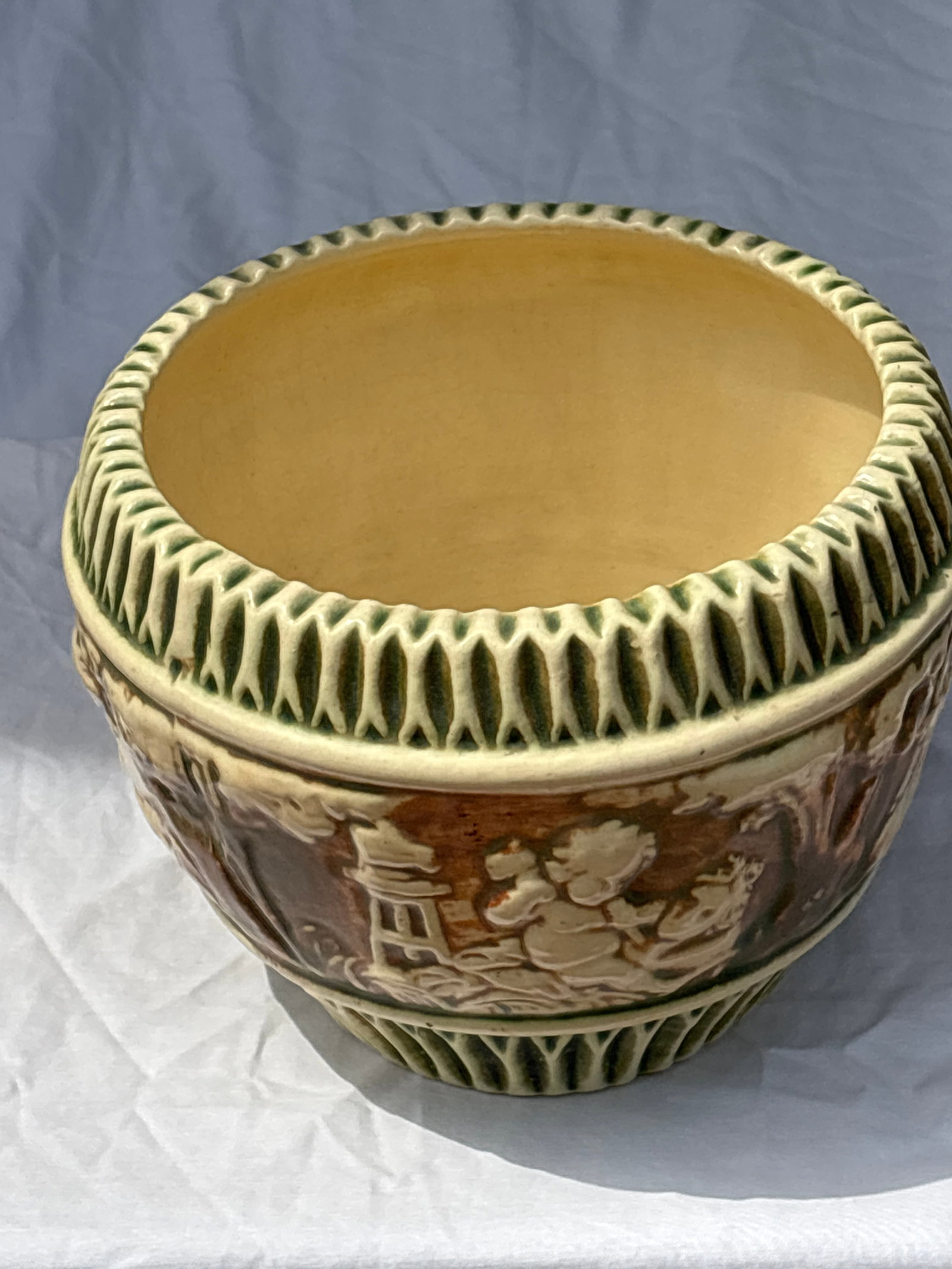 vintage Roseville Pottery Donatello 6x8 inch Jardiniere: Roseville Pottery Donatello Jardiniere introduced in 1916.It features a distinctive relief band depicting playful cherubs against a cream-colored background.The piece has green vertical fluting along 