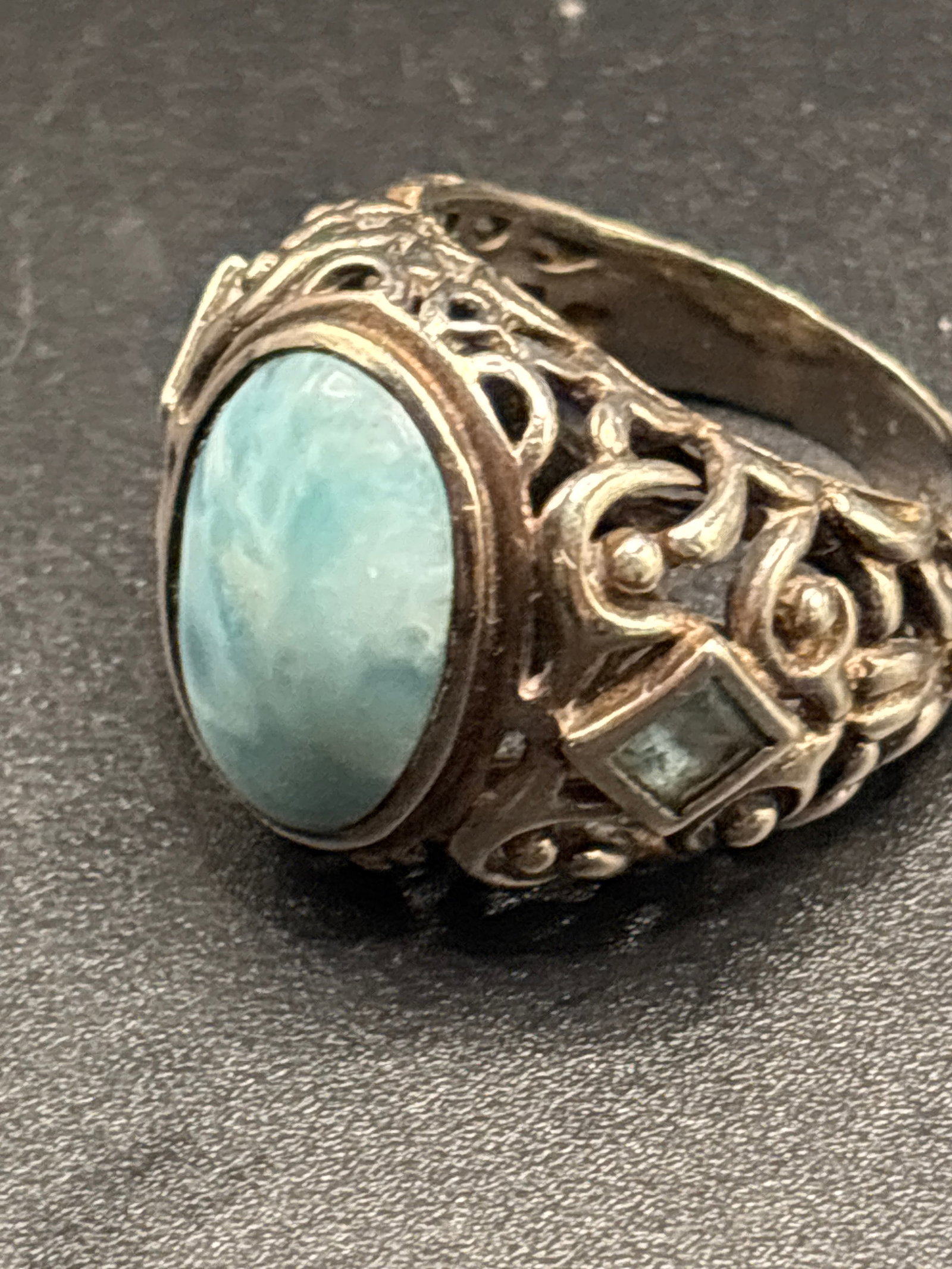 sterling silver ring features a natural oval-cut larimar stone set in an ornate scrolled band (1 of 6)