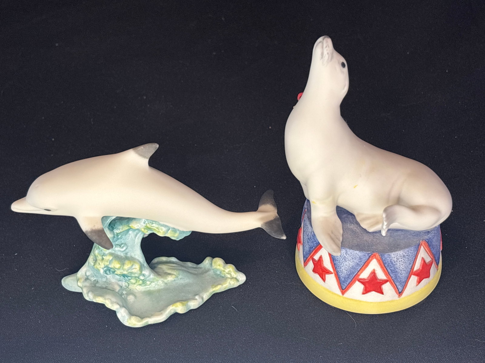 Cybis Dolphin & Sebastian the circus seal 6 inch figurines: Cybis “Sebastian the Circus Seal” porcelain figurine from 1976, sculpted by Charles Oldham and hand-painted sitting on a circus pedestal baseAND ......Cybis Bisque Porcelain Dolphin Figurine, 