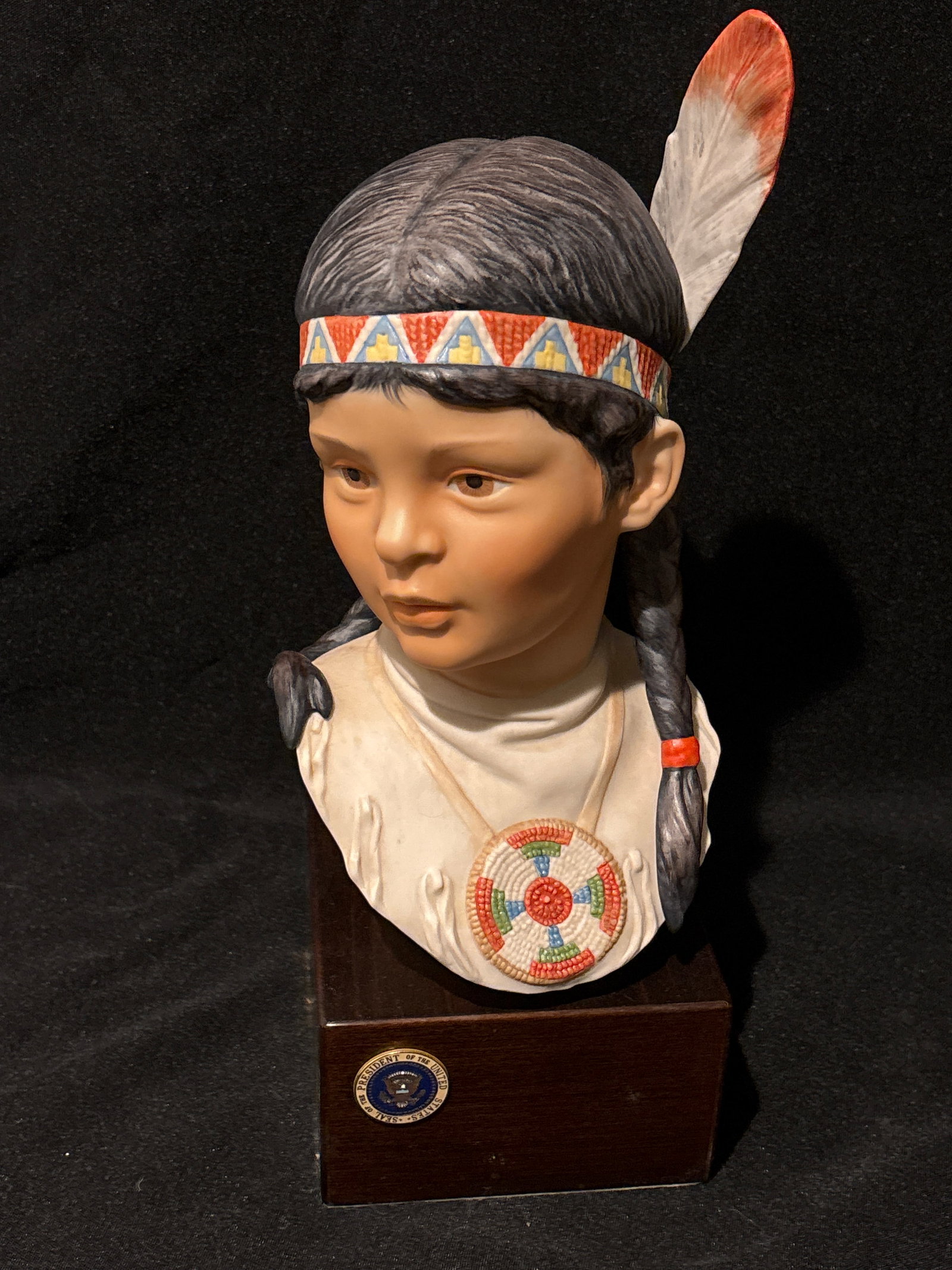 Presidential seal, Cybis Running dear (Indian Girl) 13 inch statue: This sculpture is a hand-painted porcelain bust titled "Running Deer" (Indian Girl), created by the renowned American porcelain studio Cybis. First introduced in 1975 as part of their "Children of