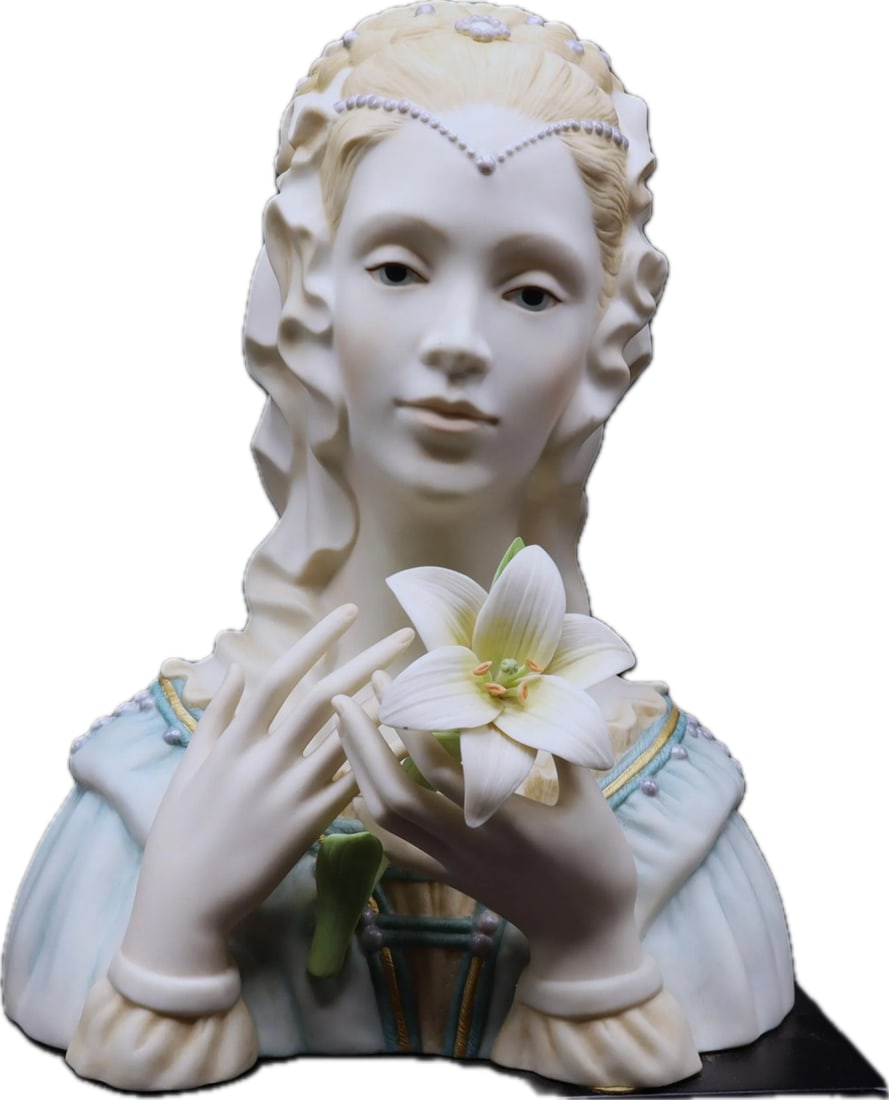 Cybis Madonna with Lily is a rare, highly collectible bisque porcelain bust sculpture: Cybis Madonna with Lily is a rare, highly collectible bisque porcelain bust sculpture released by the Cybis Porcelain studio in 1987. Known for its serene and detailed craftsmanship, it is considered 