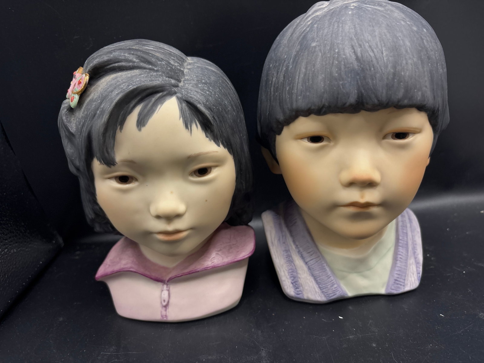 Cybis porcelain Lotus Blossom Girl & Cheerful Dragon Boy: vintage hand-painted porcelain child busts by Cybis, specifically the "Lotus Blossom" girl and "Cheerful Dragon" boy.Bust DetailsLeft Bust ("Lotus Blossom"): Cybis introduced this oriental girl figuri