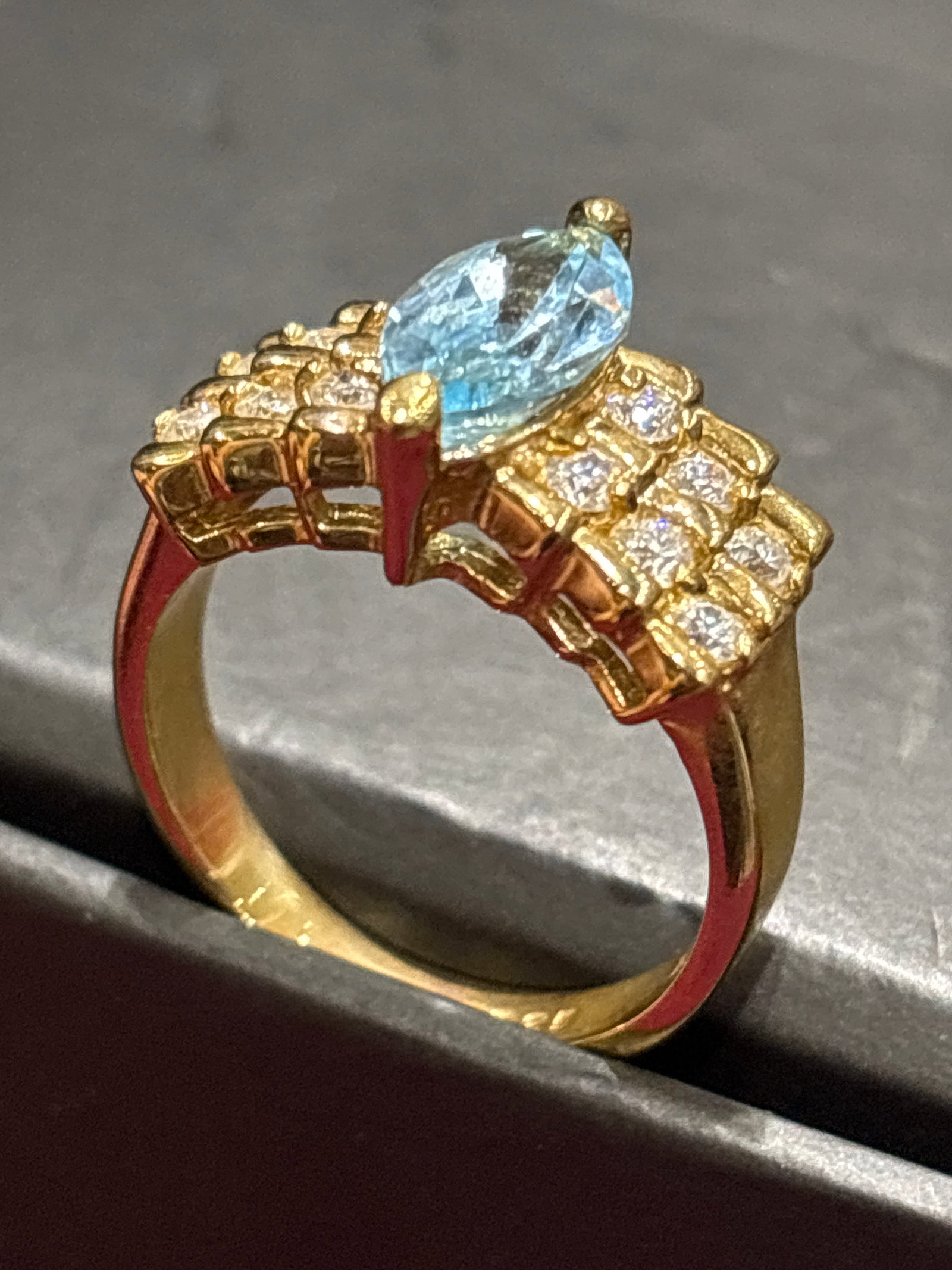 .925 blue topaz marquise-cut stone set in yellow gold color sterling: blue topaz marquise-cut stone set in yellow gold color sterling. .Maker Mark: The band is stamped with "EDCO," a maker's mark associated with jewelry production.Gemstone: The primary stone is a bright