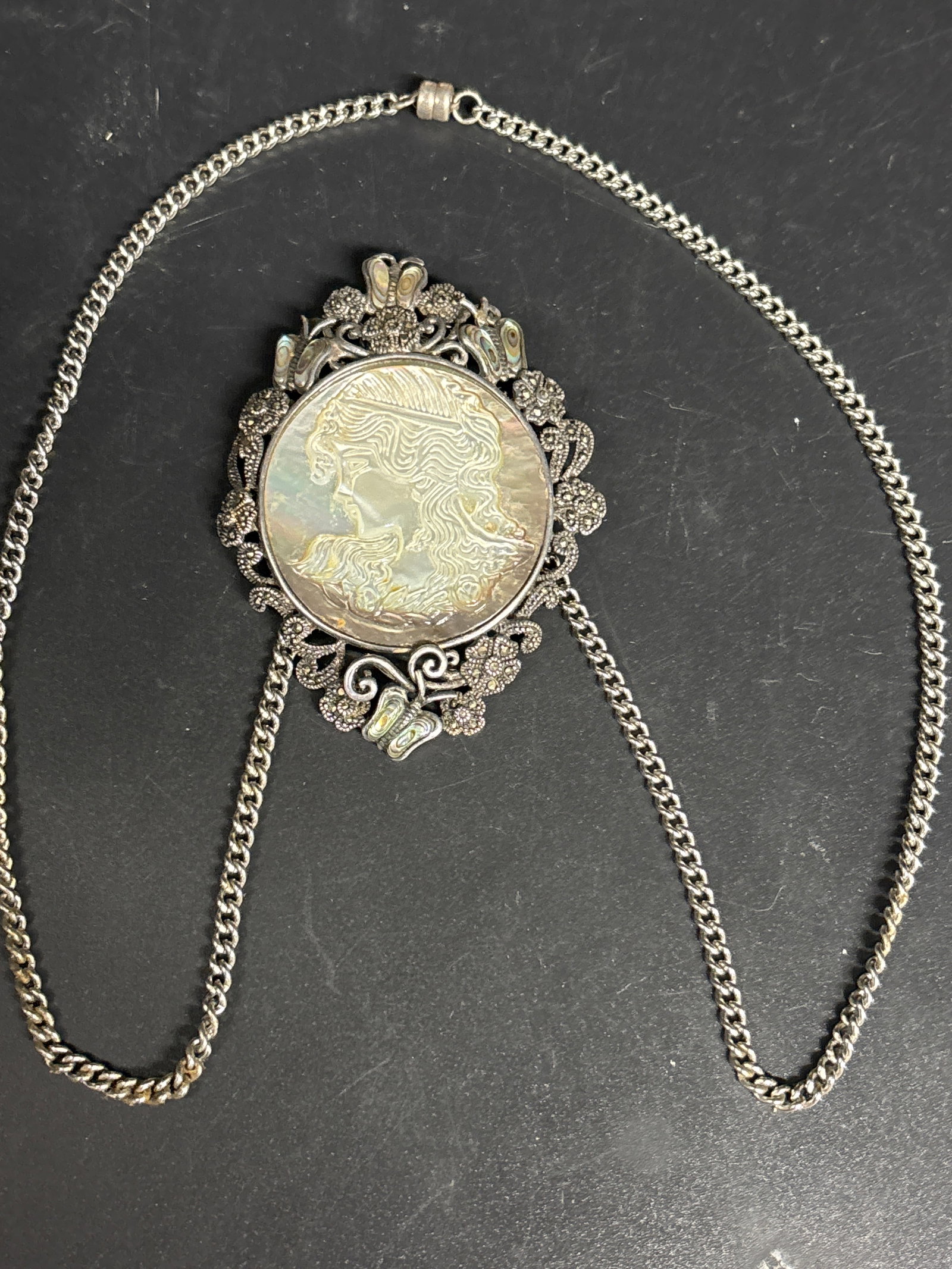Large vintage sterling carved mother of pearl necklace & ster king chain: 2&1/2 vintage-style sterling silver necklace featuring a carved mother of pearl or abalone cameo set within an ornate marcasite frame.Pendant Material: Likely 925 sterling silver set with marcasite st