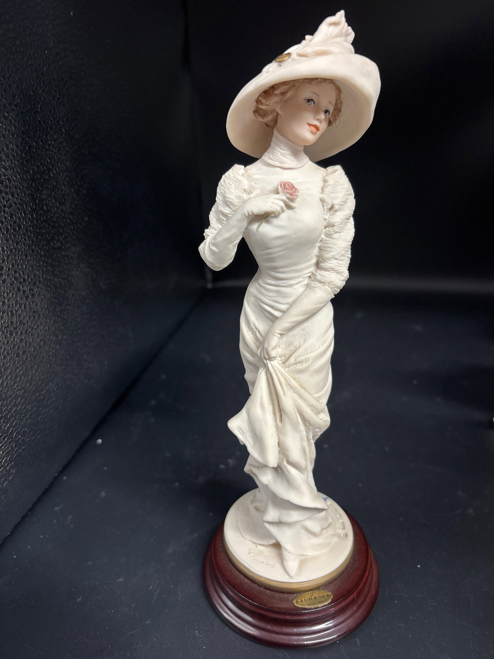 "Alice" porcelain 9 inch figurine sculpted by Giuseppe Armani for Florence Sculpture d'Arte: No box. "Alice" porcelain figurine sculpted by Giuseppe Armani for Florence Sculpture d'Arte, likely produced in the mid-to-late 1990s.The figurine depicts a woman in a large hat holding a rose and is