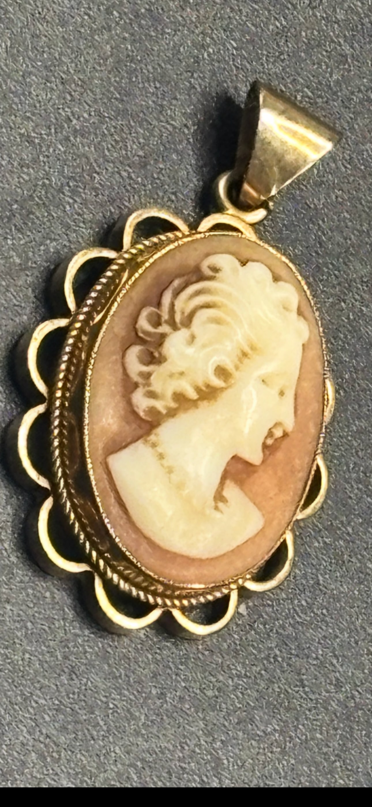 English 9 k gold vintage carved shell cameo pendant: vintage carved shell cameo pendant set in a yellow gold frame.Key Characteristics & MaterialCameo Relief: The portrait is traditional left-facing profile of a classical woman, meticulously hand-carved