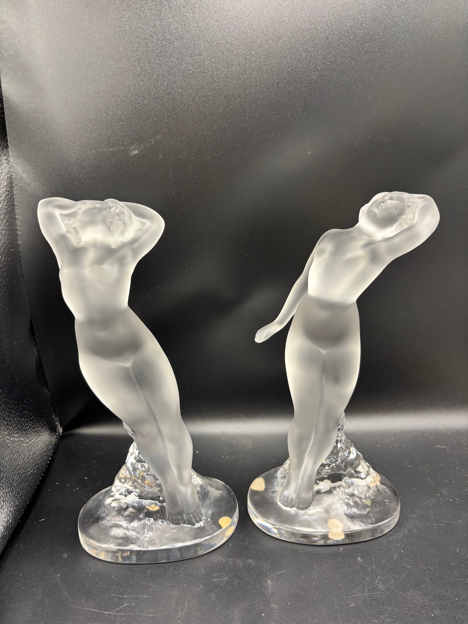 Large Original pair of Lalique satin-finished and clear crystal nude dancer 9.5 inch figurines: pair of Lalique satin-finished and clear crystal nude dancer figurines.Identification & DetailsTitle: "Danseuse Bras Levés" (Dancer with Arms Raised)Model Number: 11908Designer: Designed by Marc Lali