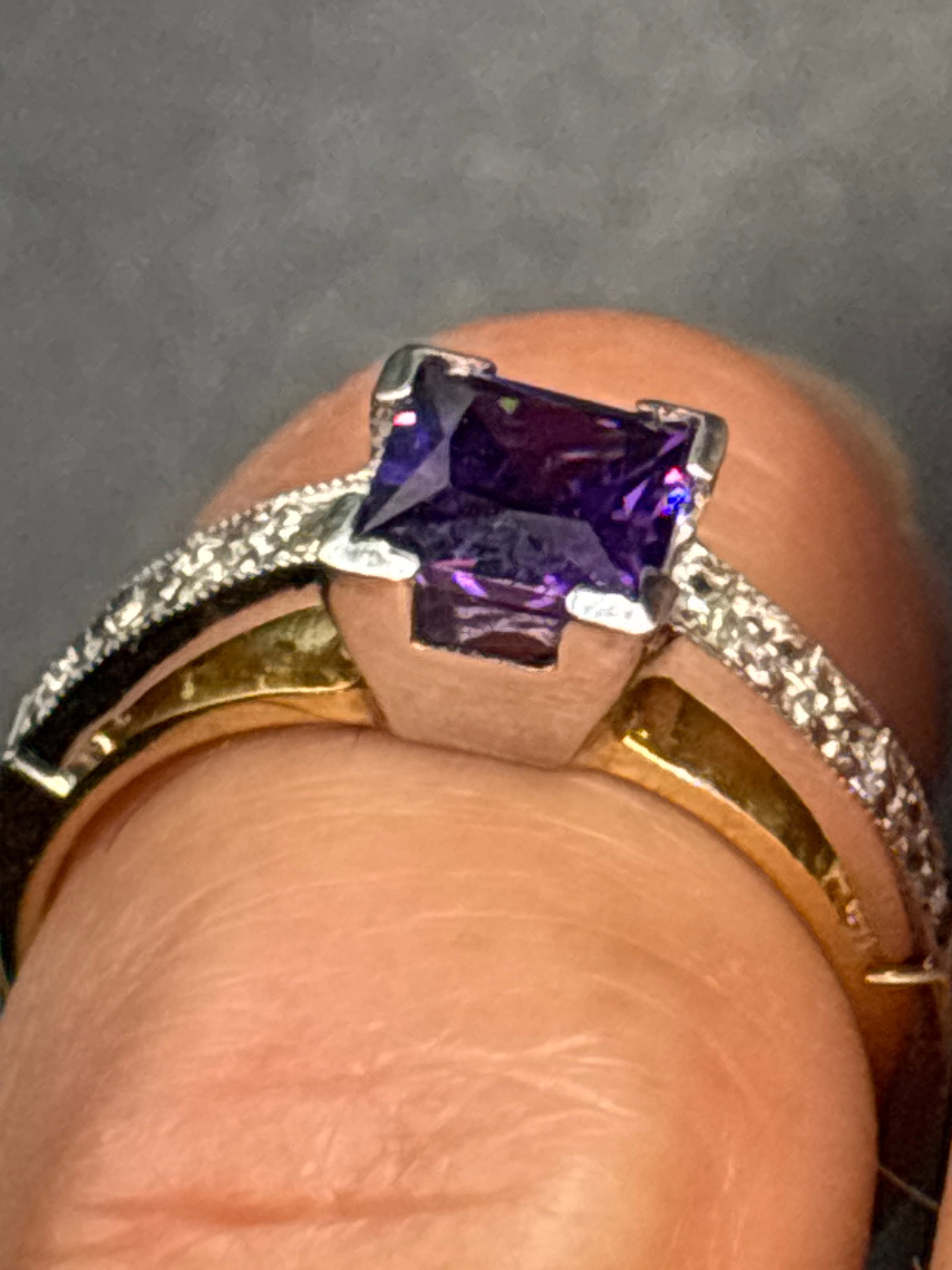 3.86 grams 14 k gold two-tone ring features a princess-cut amethyst: 3.86 grams 14 k gold two-tone ring features a princess-cut amethyst set in white gold or platinum, with diamond accents along the yellow gold band.Materials: Typically constructed from 14K or 18K yell